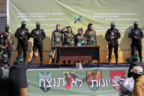Karina, Liri, Daniela and Naama on stage at the Hamas rally dressed in uniforms next to a sign says “Zionism Won’t Win” in Hebrew.  