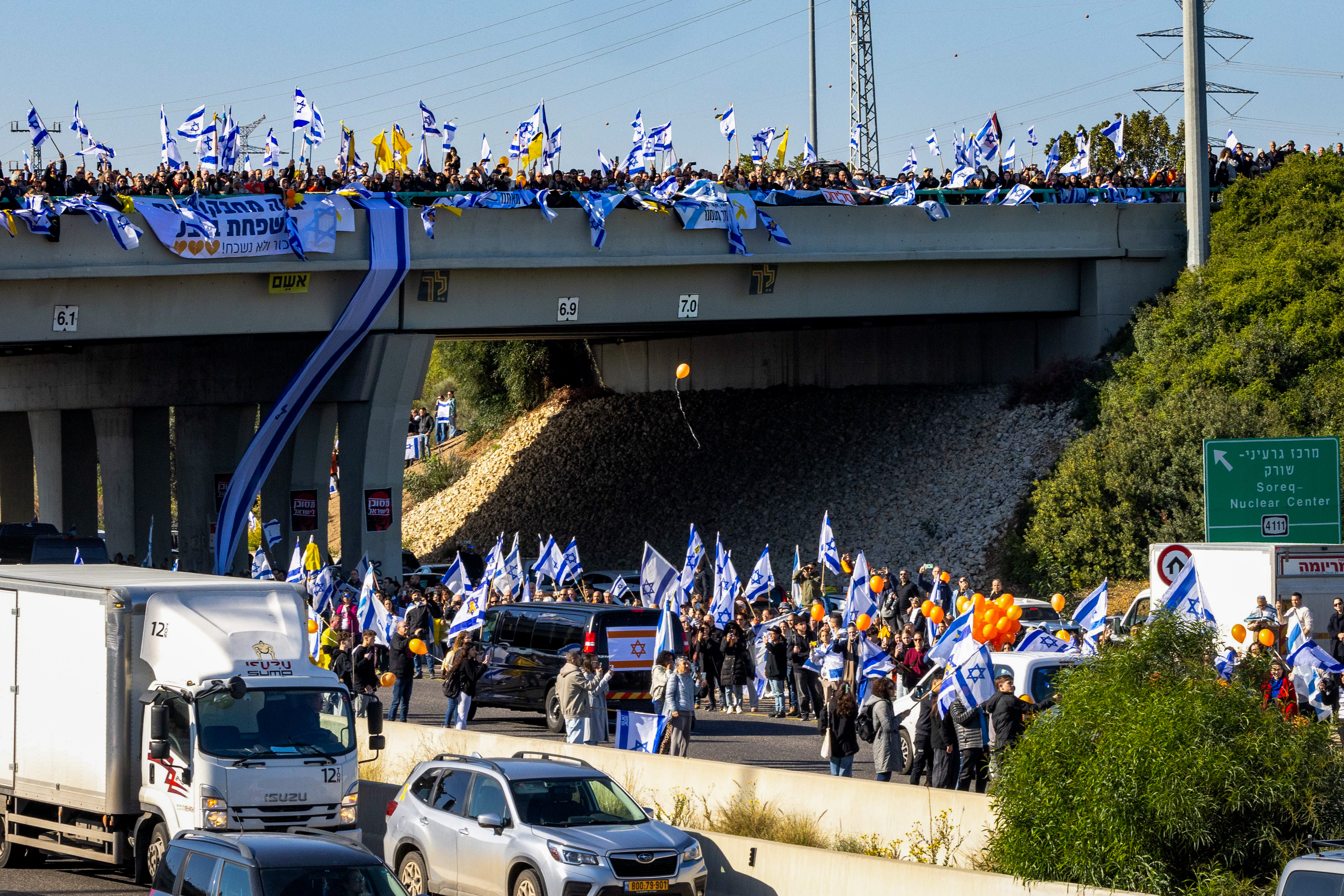 People pay their respects during the funeral service of late Israeli hostages Shiri Bibas and her children Ariel and Kfir, Gan Yavne Intersection, February 26, 2025