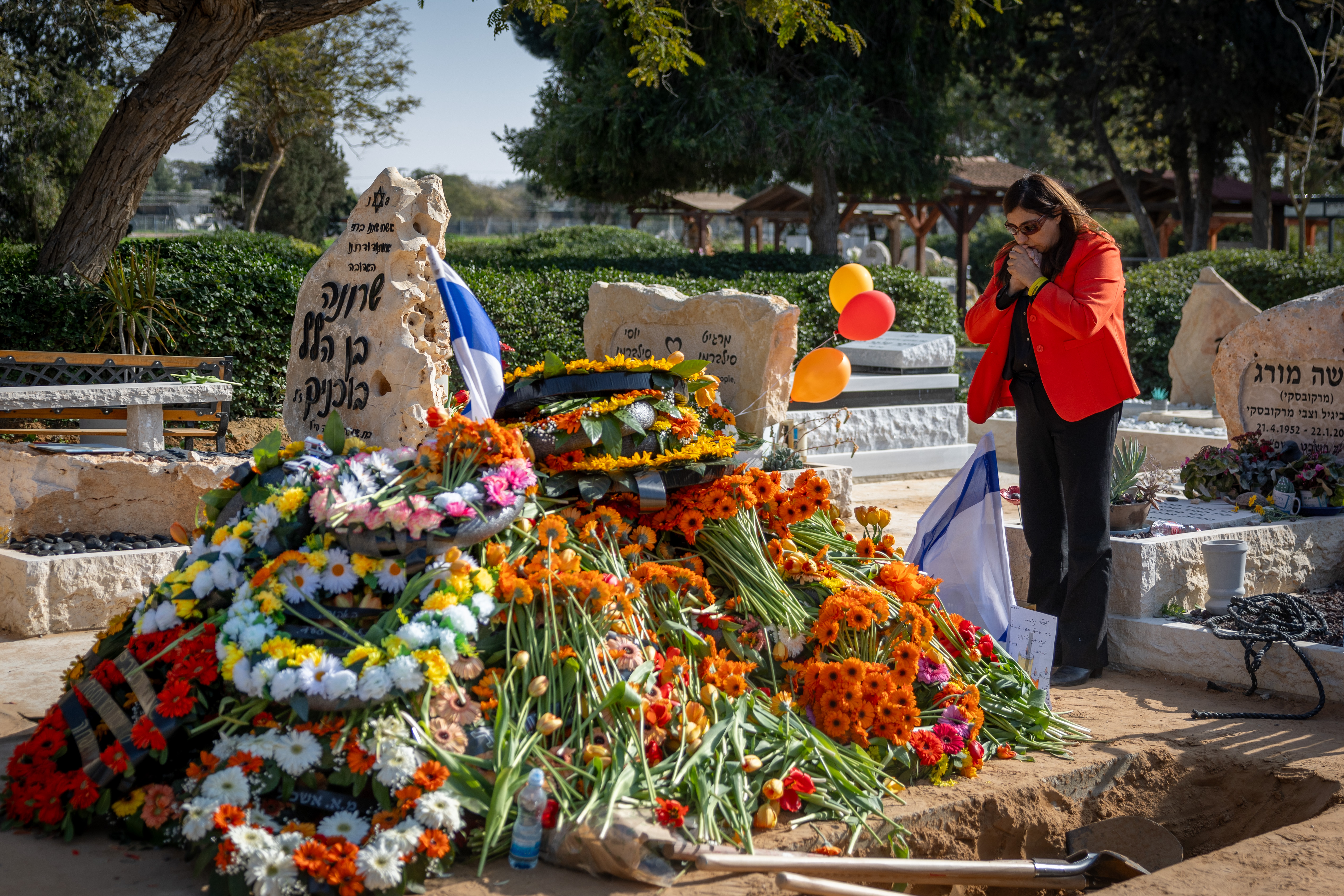 Mourners near the fresh grave of late Israeli hostages Shiri Bibas and her children Ariel and Kfir at the cemetery in Tzohar, southern Israel, February 26, 2025. 