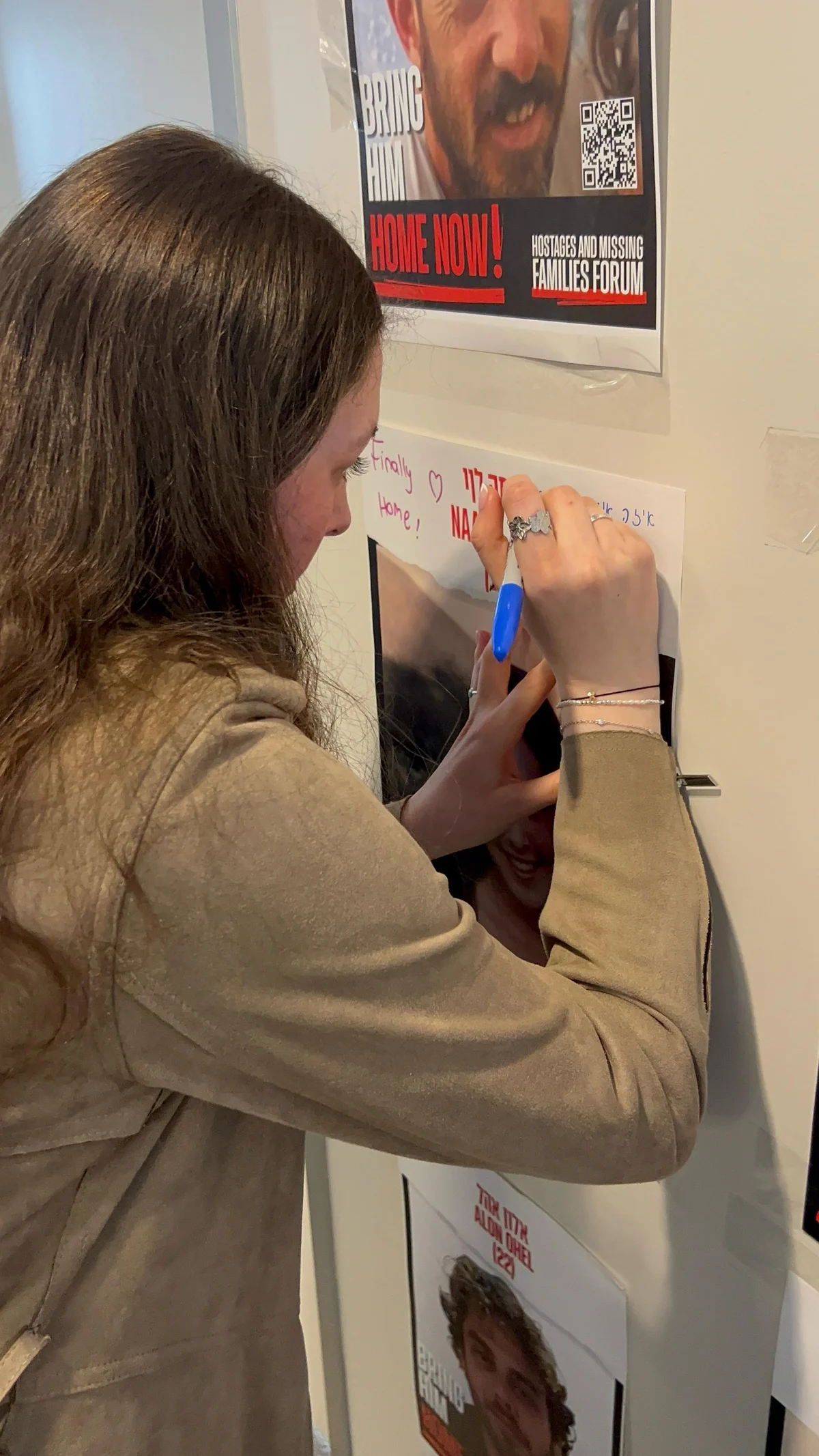 Naama Levi writing on her hostage poster