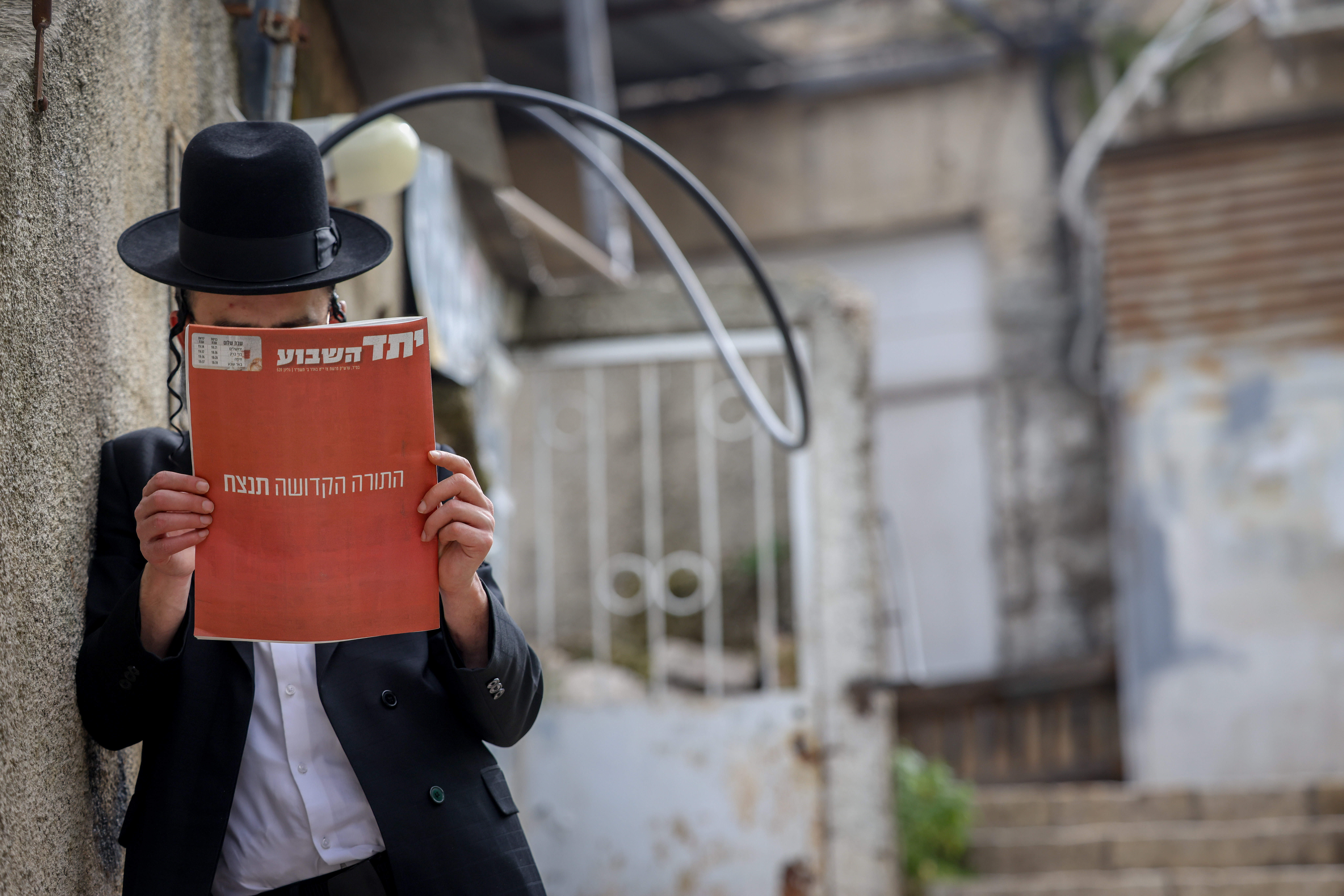 An Ultra Orthodox Jewish man reads the "Yated Ne'eman" newspaper in Jerusalem's Mea Shearim neighbourhood on March 29, 2024.