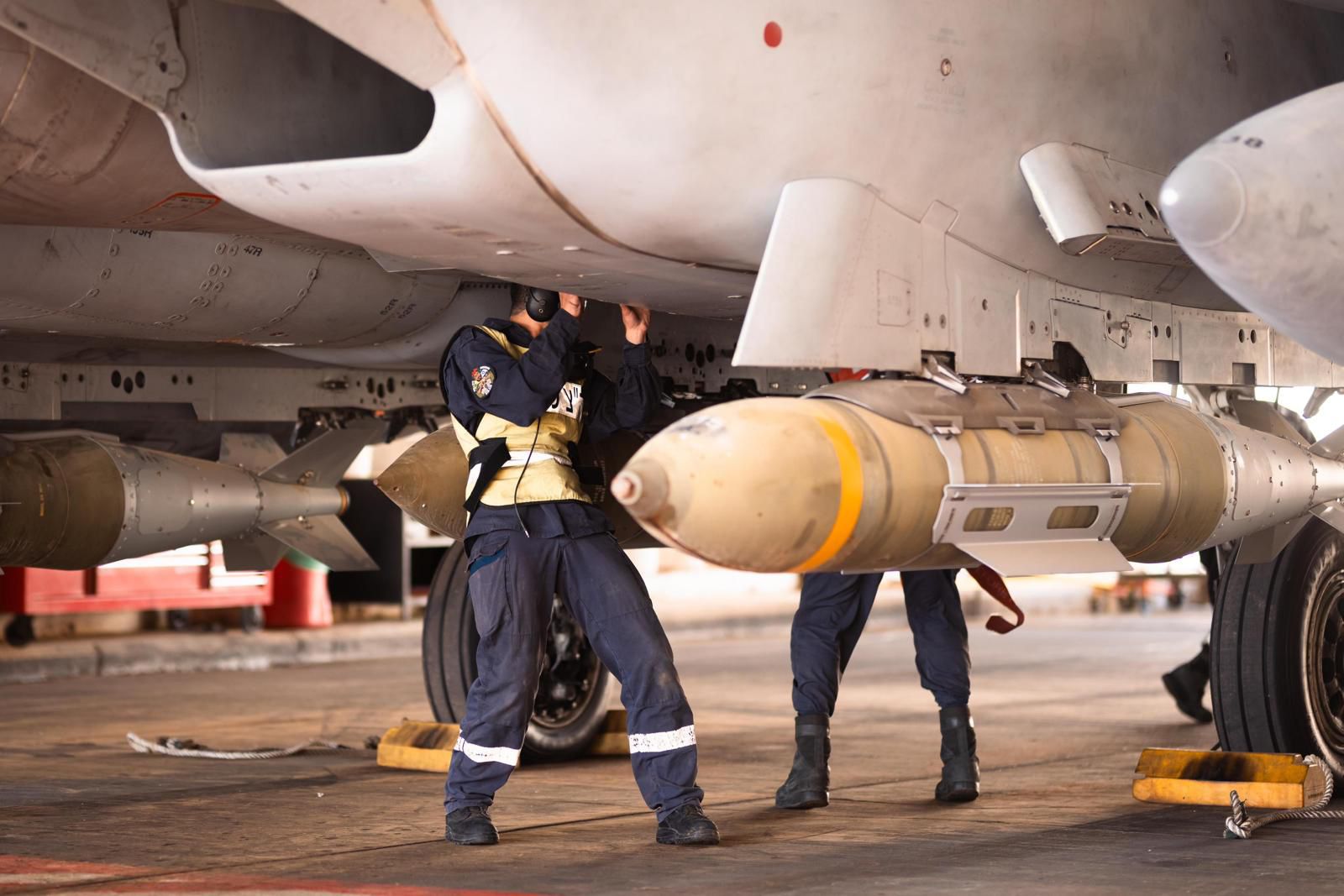 Technicians handling bombs.