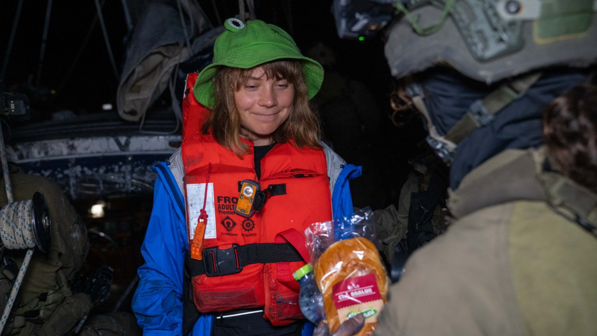 Greta being offered a sandwich on the flotilla.