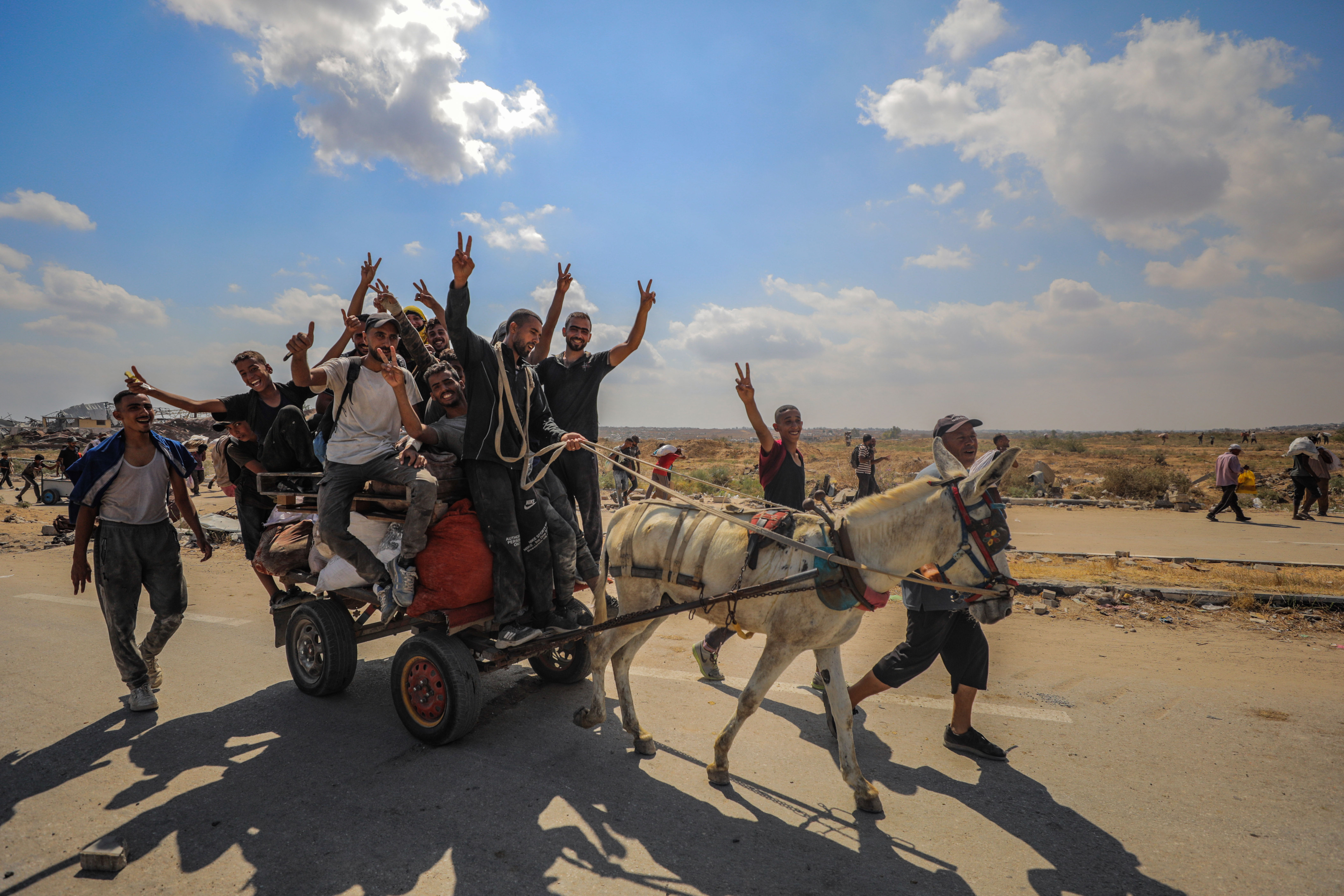 Displaced Palestinians carry food parcels and supplies from a GHF aid distribution point at the “Netzarim corridor” in the central Gaza, August 4, 2025. 