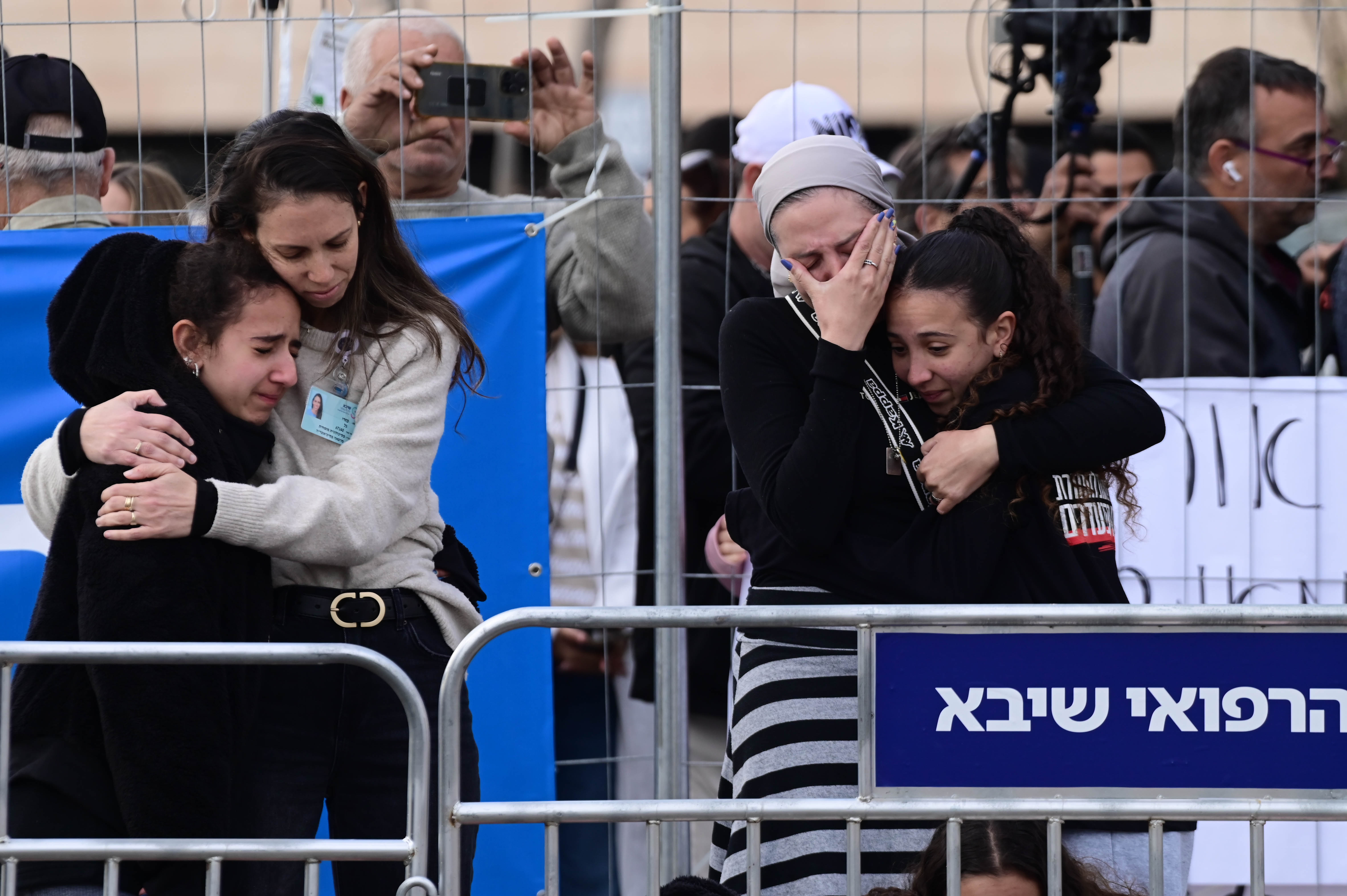 People wait for the arrival of released hostages Or Levy and Eli Sharabi at the Sheba Medical center in Ramat Gan