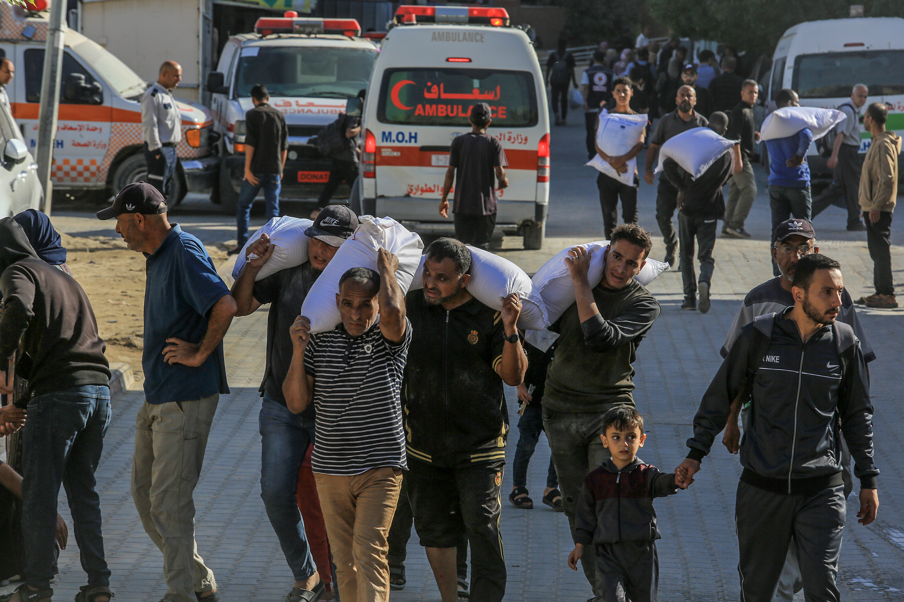 Palestinians carry bags of flour stolen from humanitarian aid trucks entering the Gaza Strip, in Khan Yunis, southern Gaza Strip, May 31, 2025.