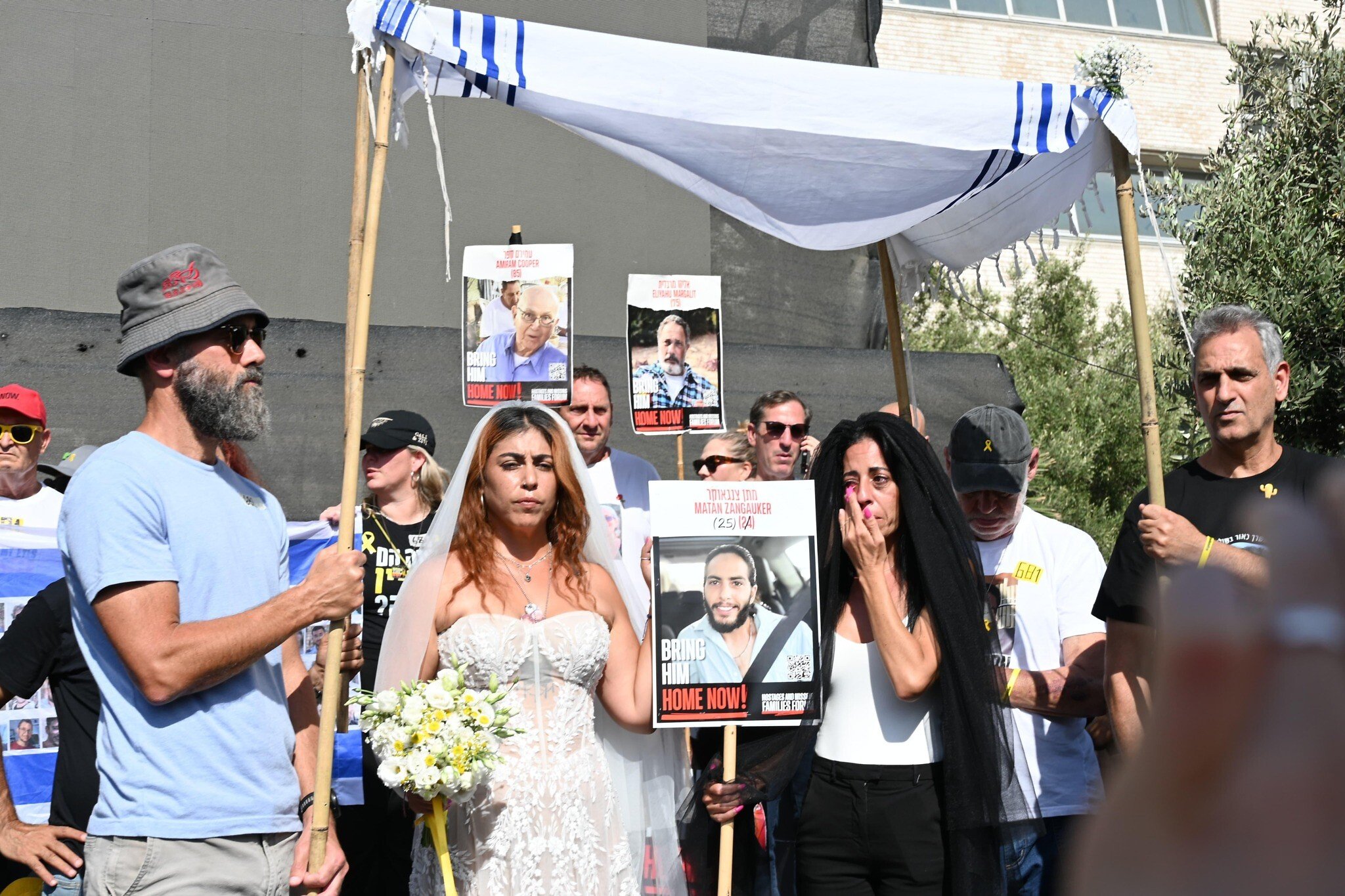 Ilana Gritzewsky (center), John Polin (left), and Einav Zangauker (right) stage a mock wedding between Gritzewsky and her boyfriend Matan Zangauker who is still being held captive in Gaza