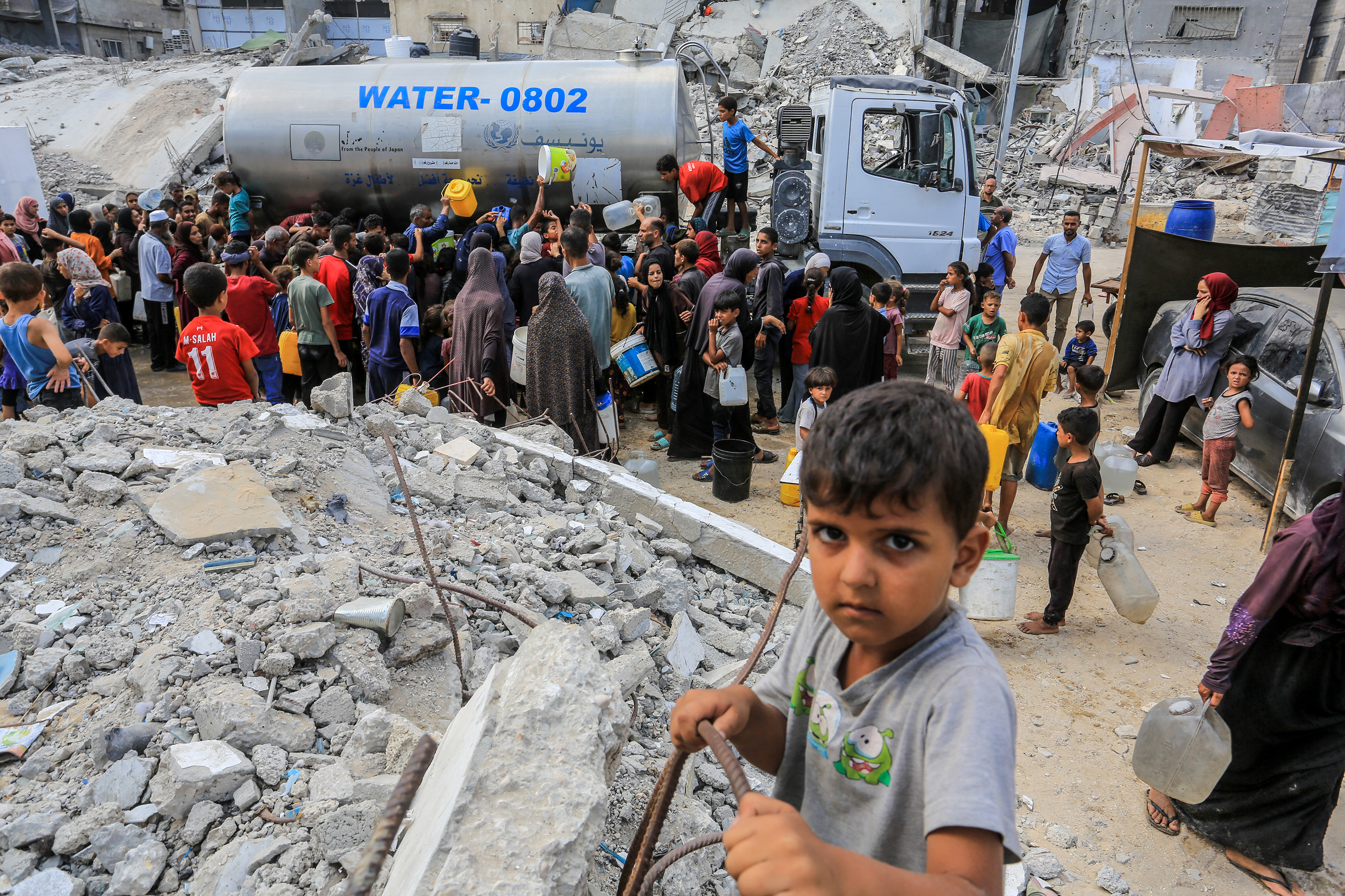 Palestinians collect drinking water in Khan Yunis, in the southern Gaza Strip, August 18, 2025.