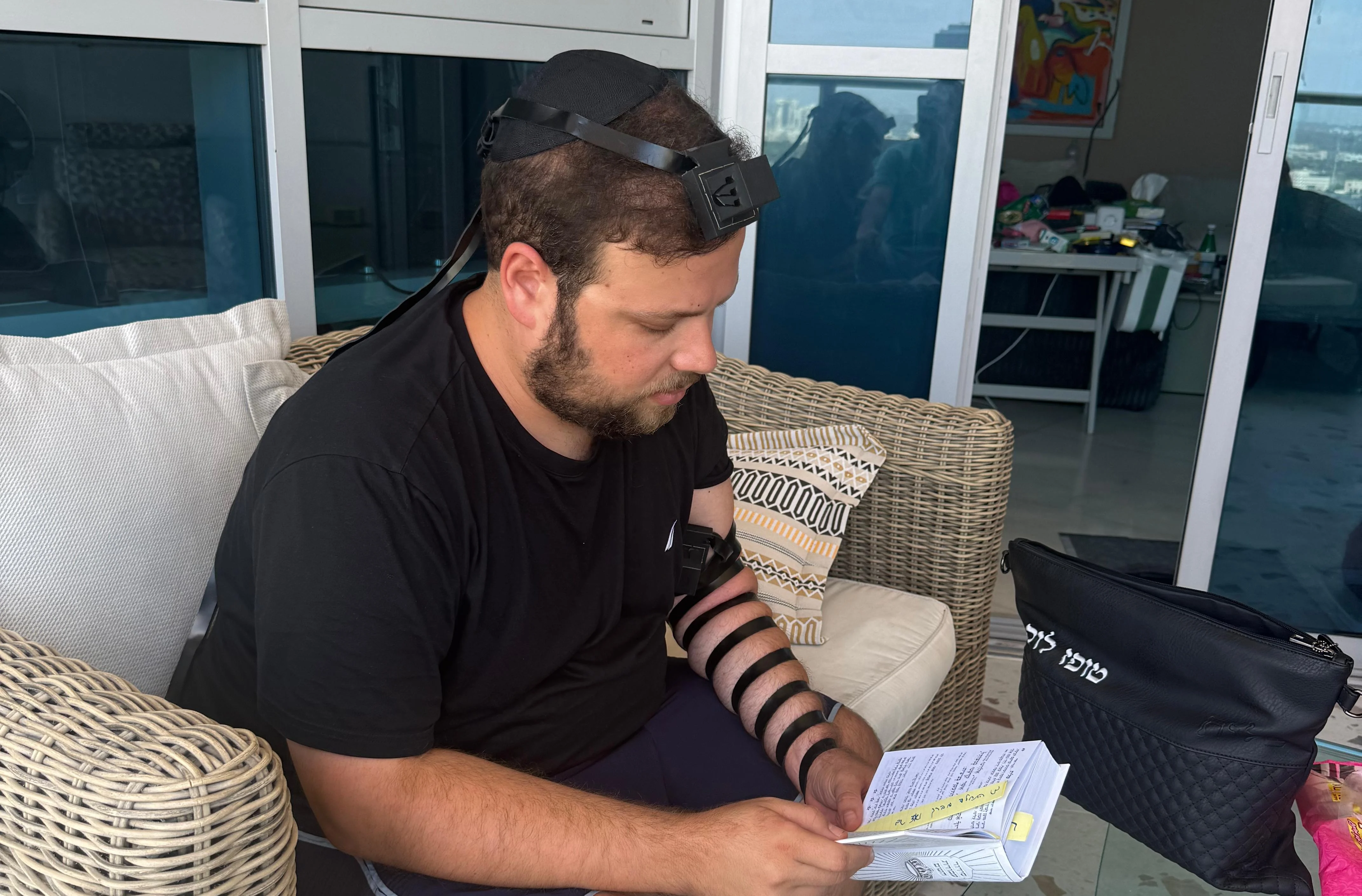 Topaz Luk putting on tefillin every morning.