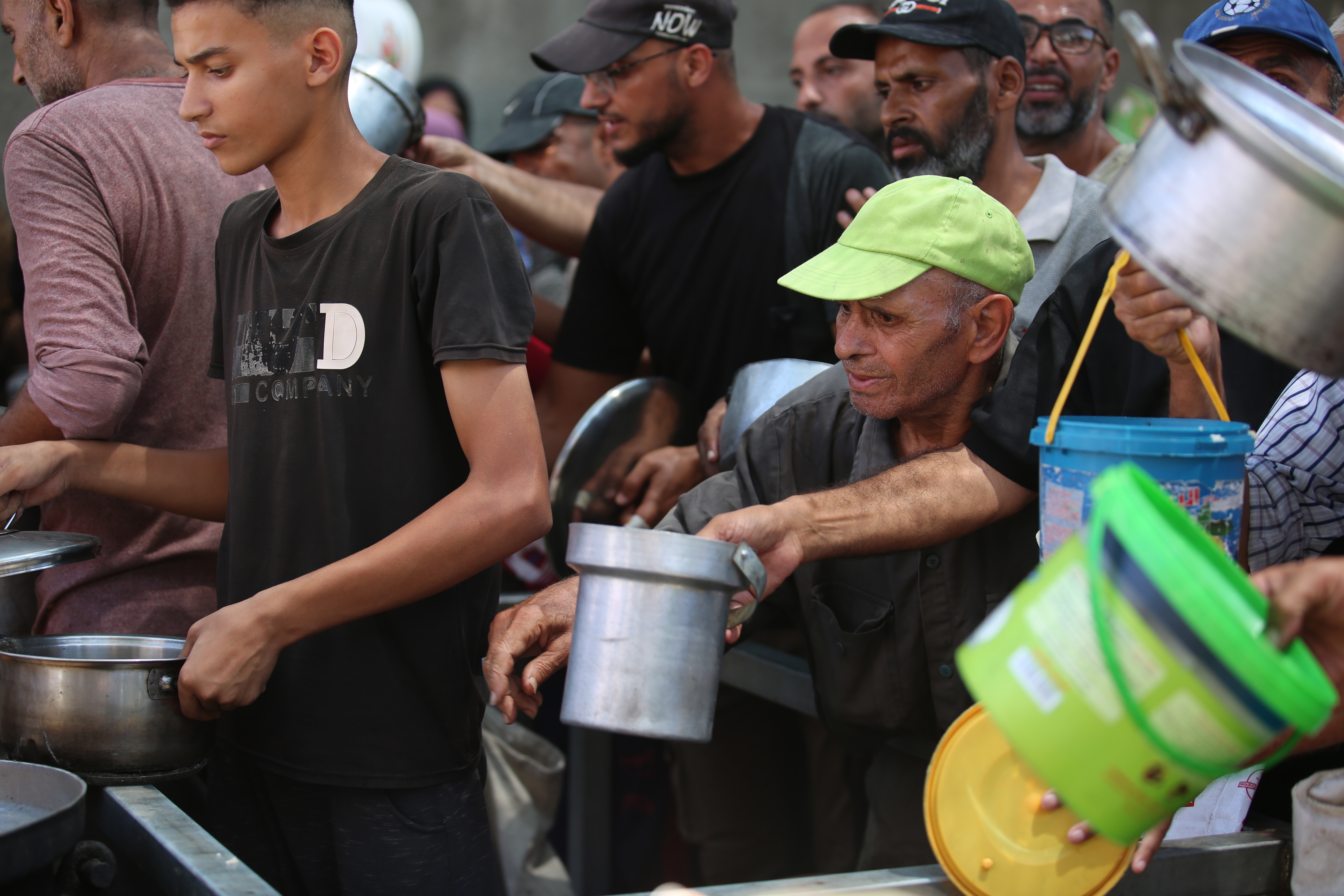 Palestinians receive meals from volunteers in Gaza City, on August 23, 2025.