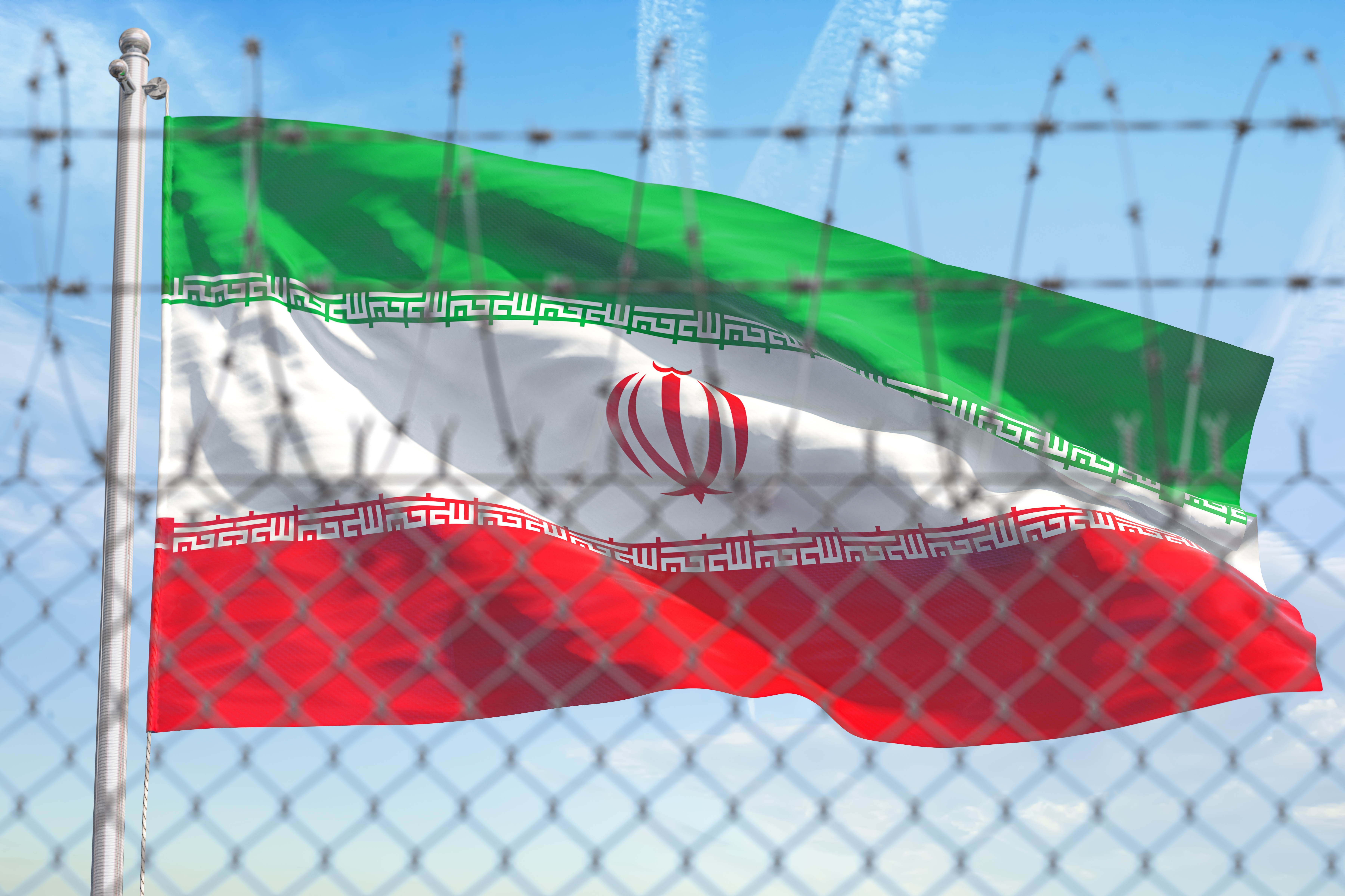 Flag of Iran behind barbed wire fence. 