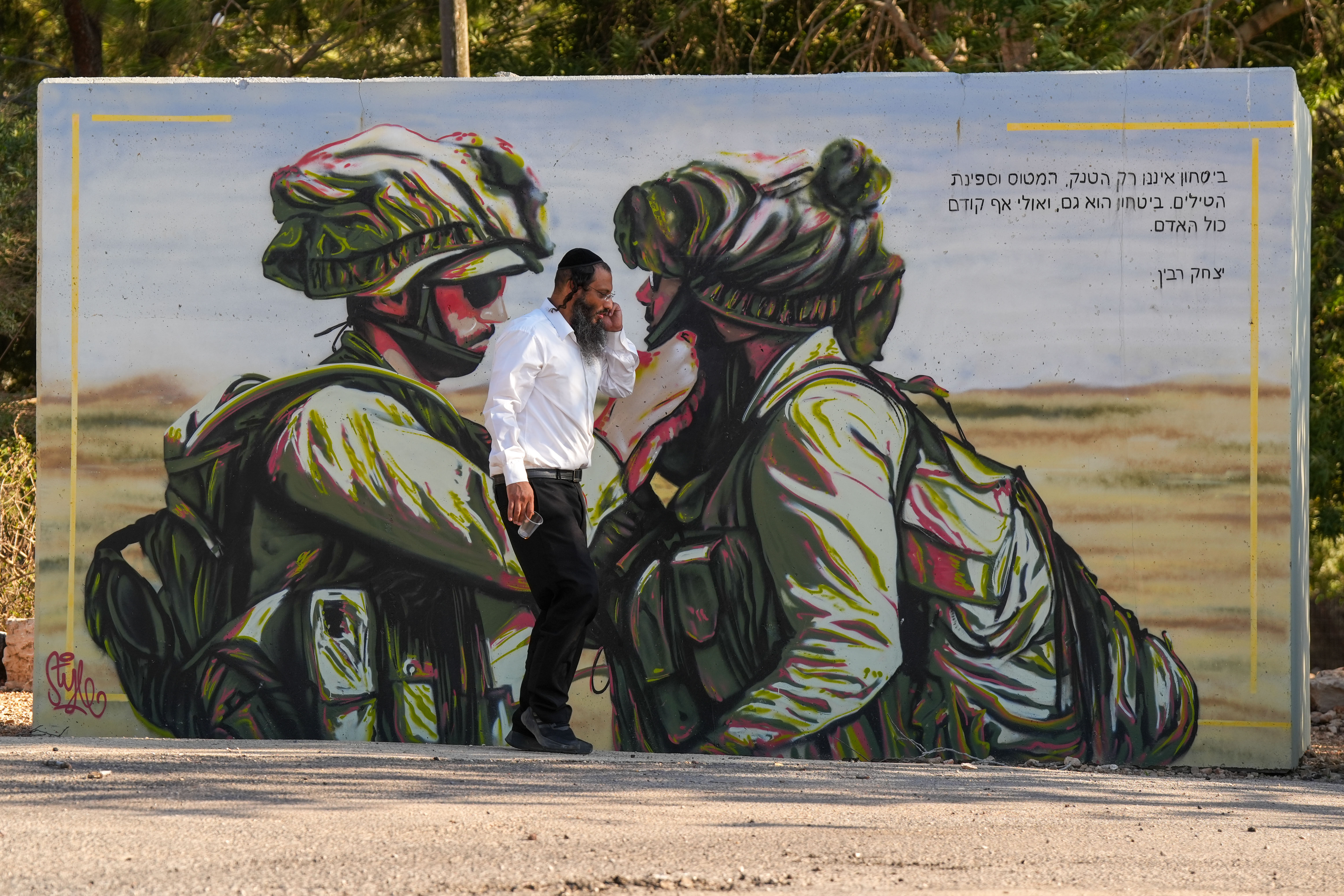 An ultra orthodox Jewish man walks past a public bombshelter with illustration of Israeli soldiers, in Northern Israel. September 10, 2025. 