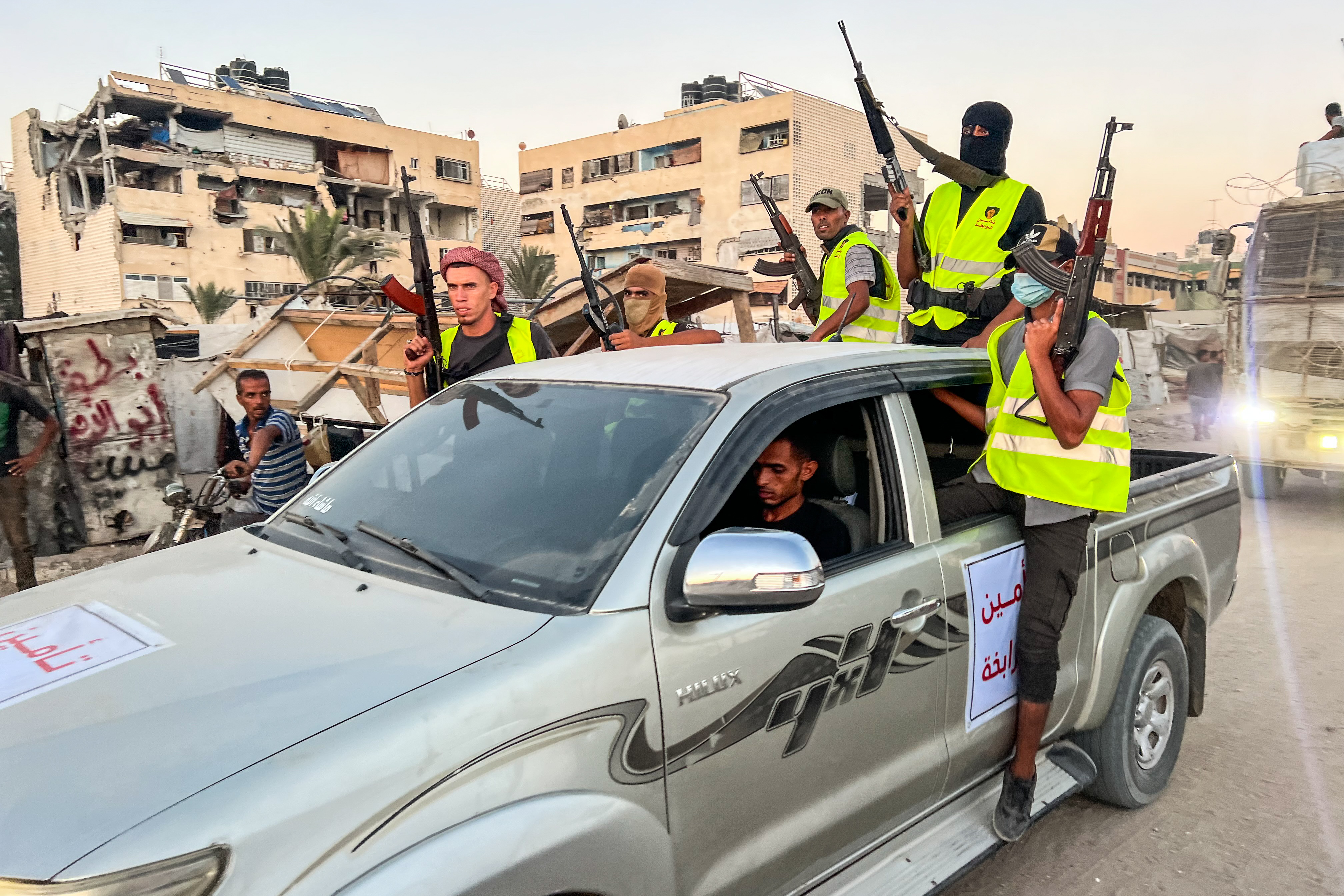 Armed Palestinians secure trucks loaded with Humanitarian Aid entering Gaza through the Israeli Kerem Shalom Crossing, in Khan Yunis, in the southern Gaza Strip, September 19, 2025. 