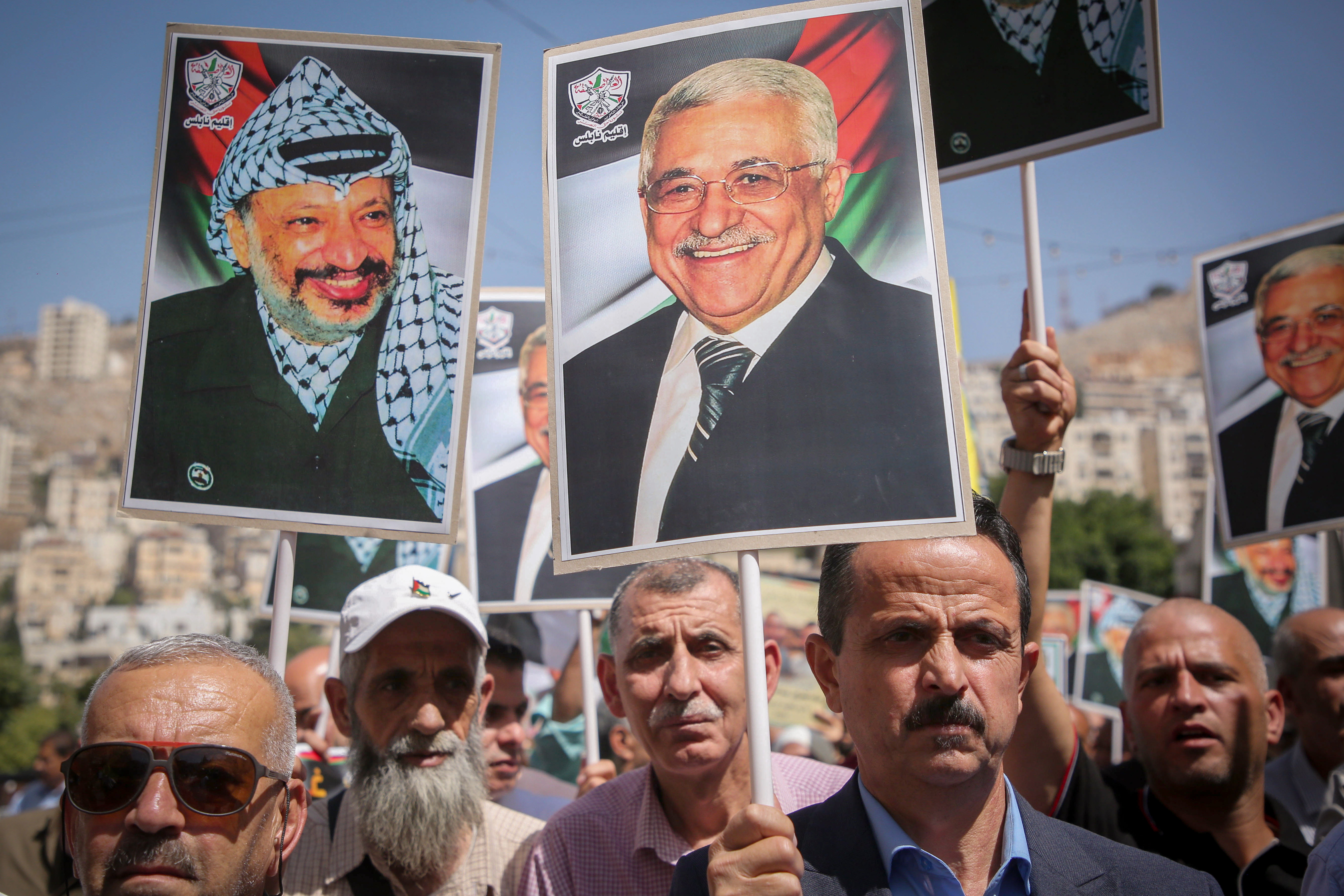 Palestinians chant and wave Palestinian flags and pictures of the late President Yasser Arafat and Mahmoud Abbas during a rally in Nablus 
