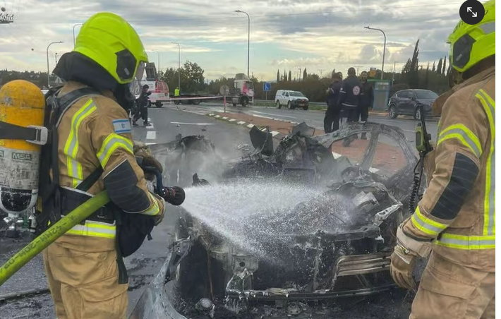 Firefighters extinguish burning car