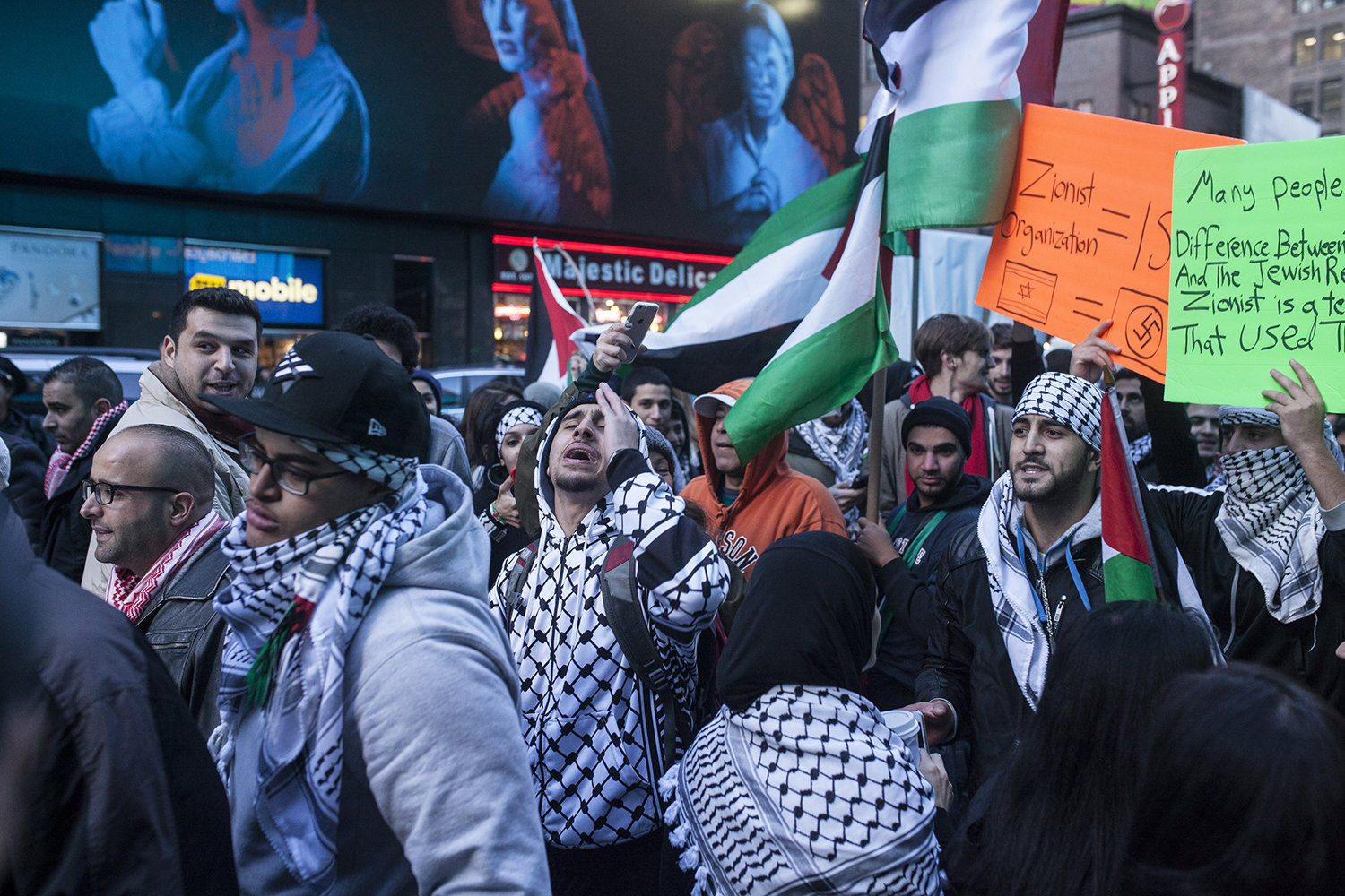pro-Palestine demonstrators chants chant slogans and hold up signs as they march next to a Pro-Israel protest in Times Square, New york on October 18, 2015. 