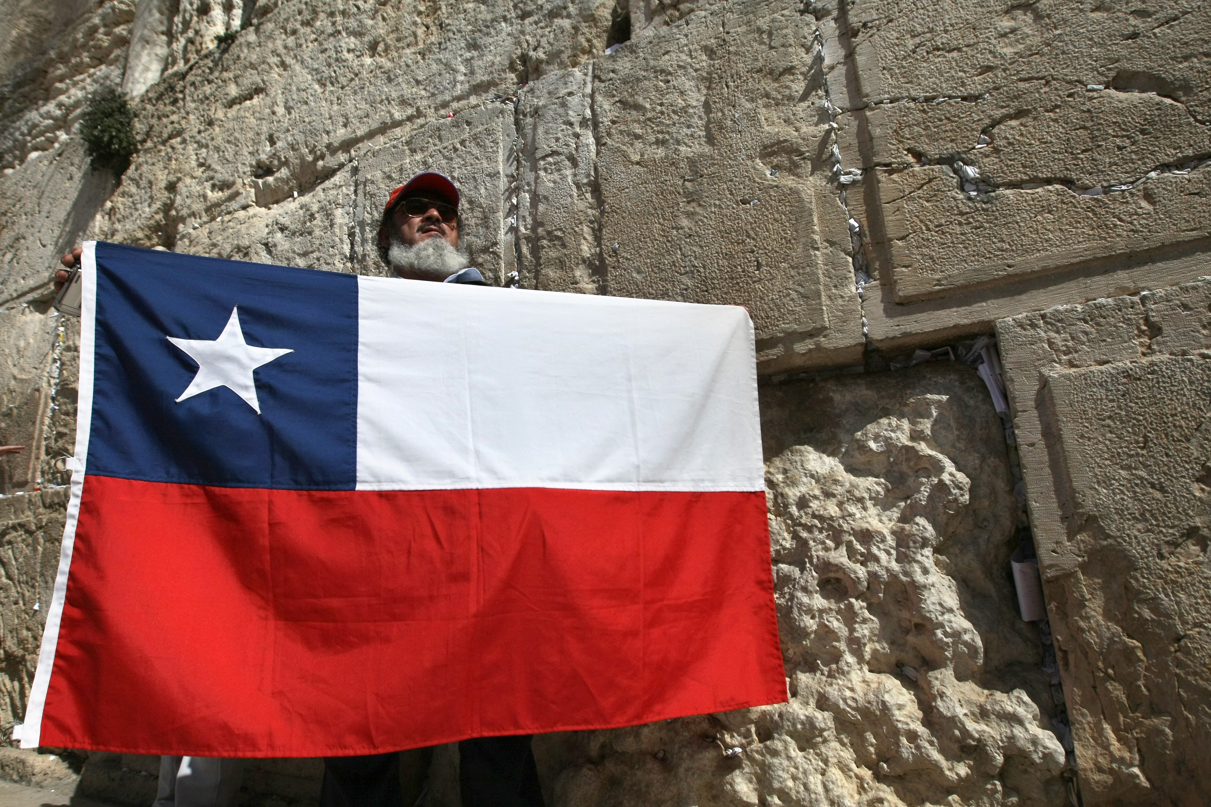 A Chilean Miner who survived a grueling 69-day ordeal trapped in a caved-in gold and copper mine in Chile, stands with Chile flag during a visit at the Western Wall in Jerusalem's Old City on February 24, 2011.