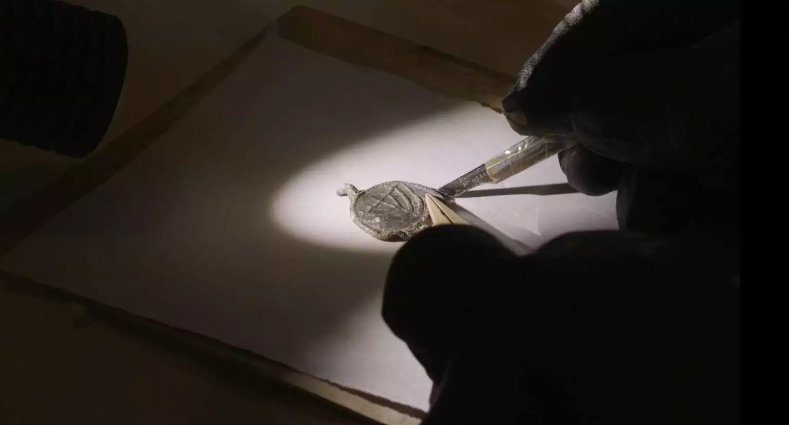 Conservation treatment to remove the weathering layer that had accumulated on the pendant.