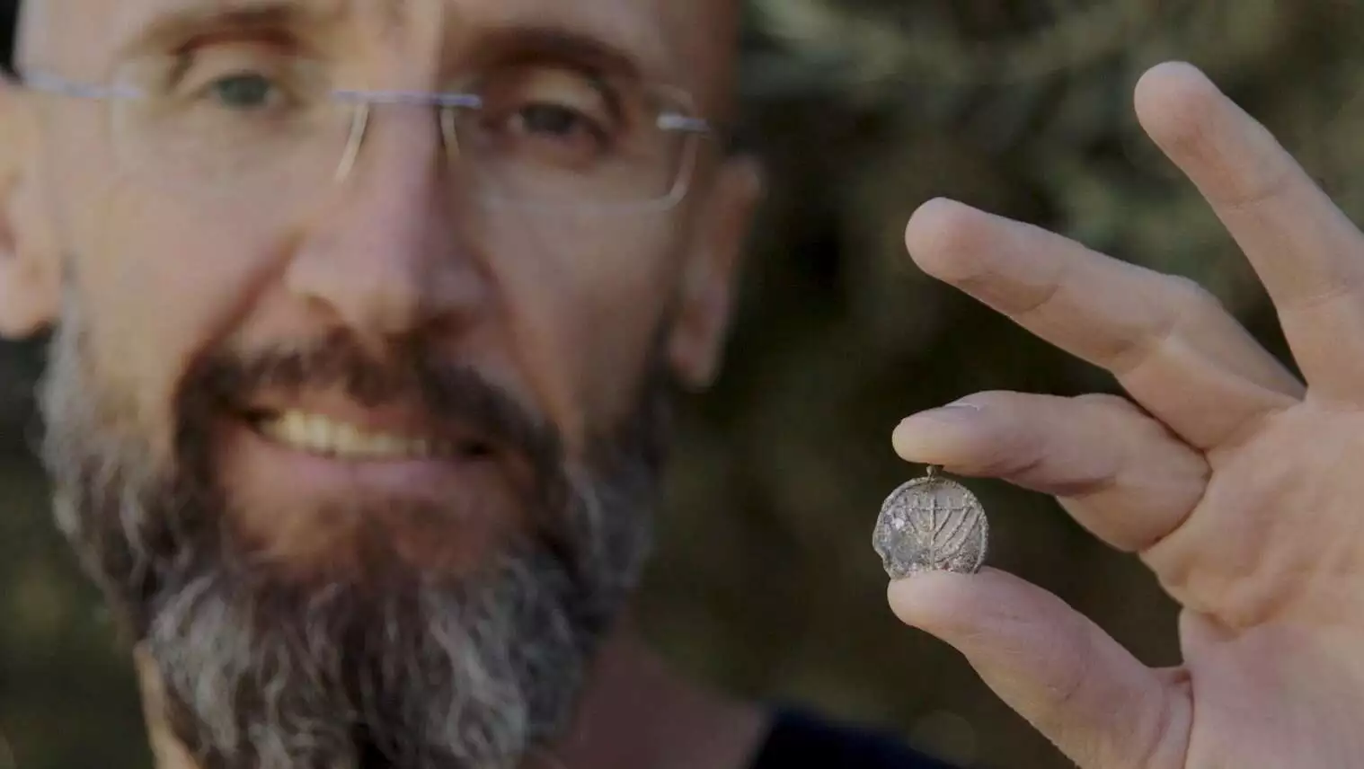 Dr. Filip Vukosavović holding the menorah pendant.
