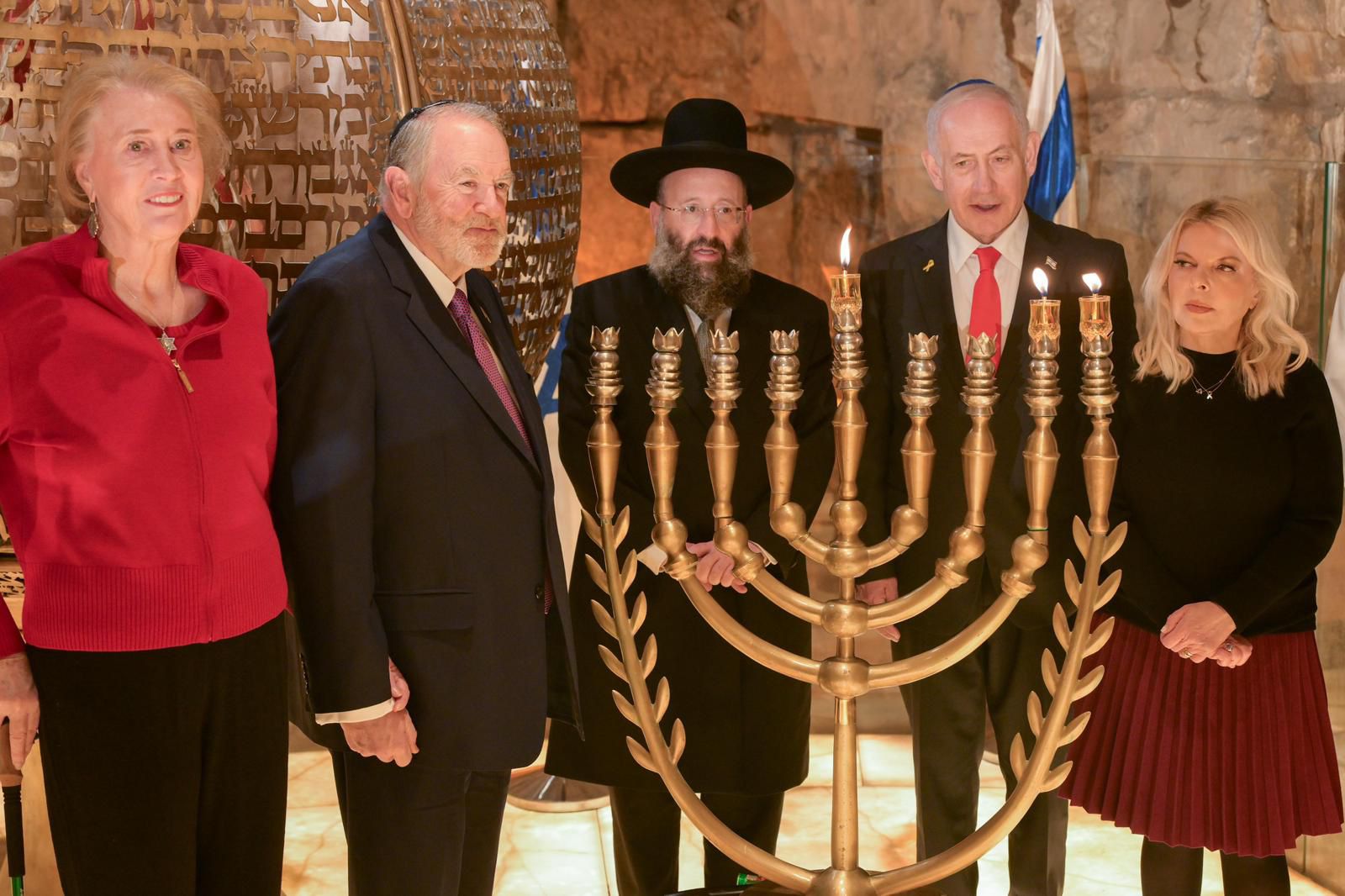 The Netanyahus, the Huckabees, and Rabbi Rabbinowitz lighting the candles at the Kotel.