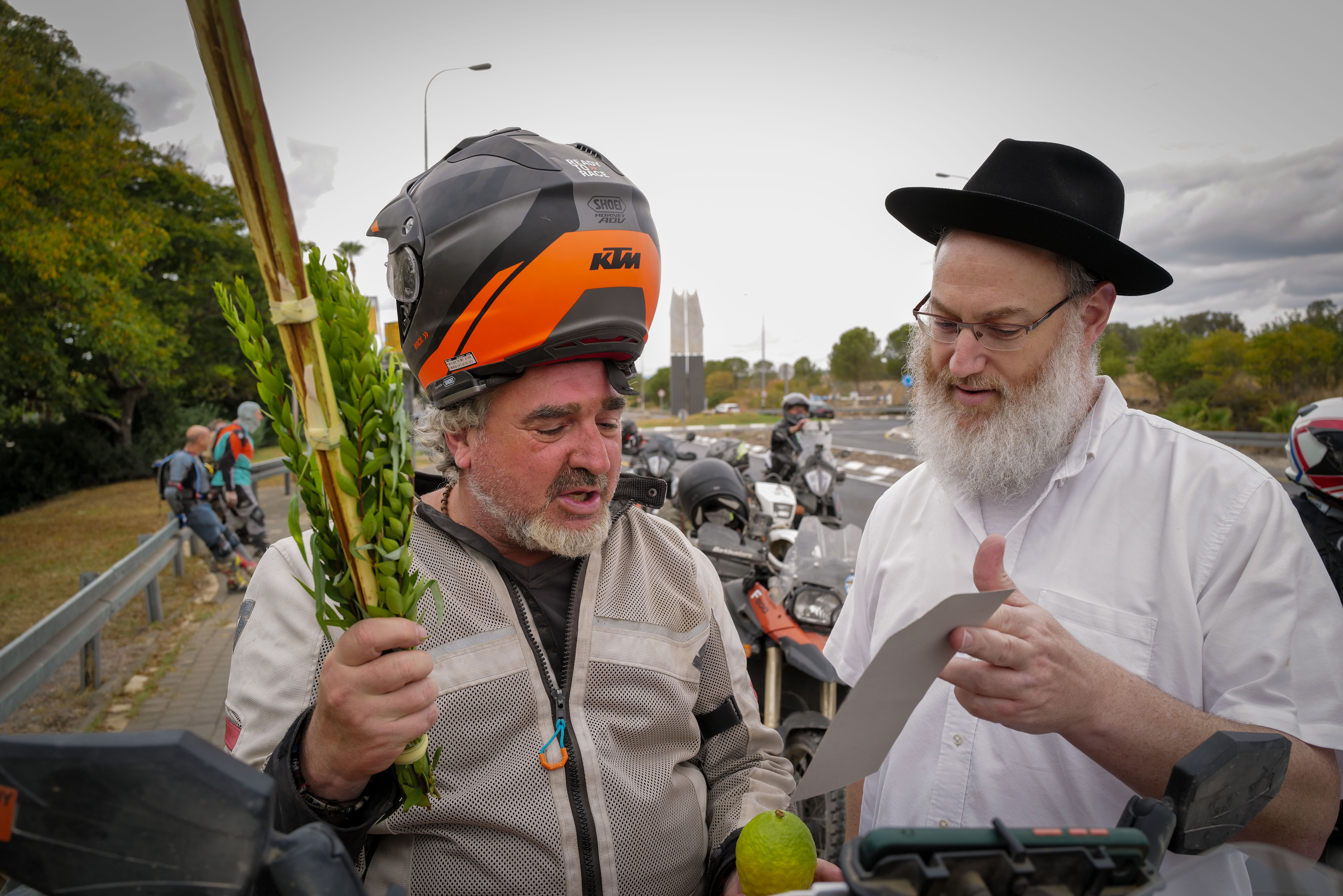 An orthodox Jew from the Habad organization offers a group of bikers to take part in the Mitzvah of the four species of the Sukkot Holiday in Katsrin, Golan Heights on October 1, 2023. 