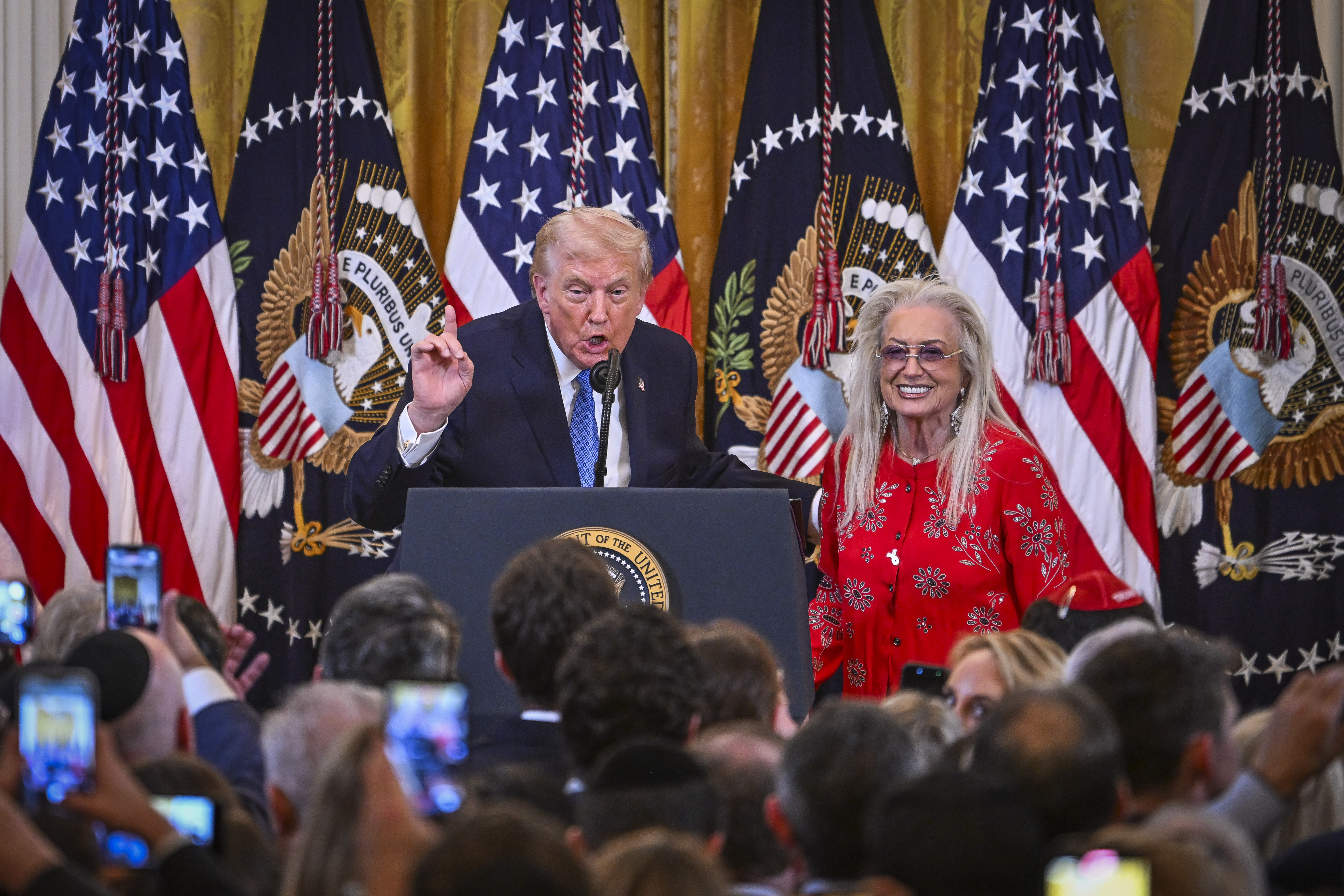 U.S. President Donald Trump and Miriam Adelson attend a Chanuka reception in the East Room of the White House in Washington, D.C., on December 16, 2025. 