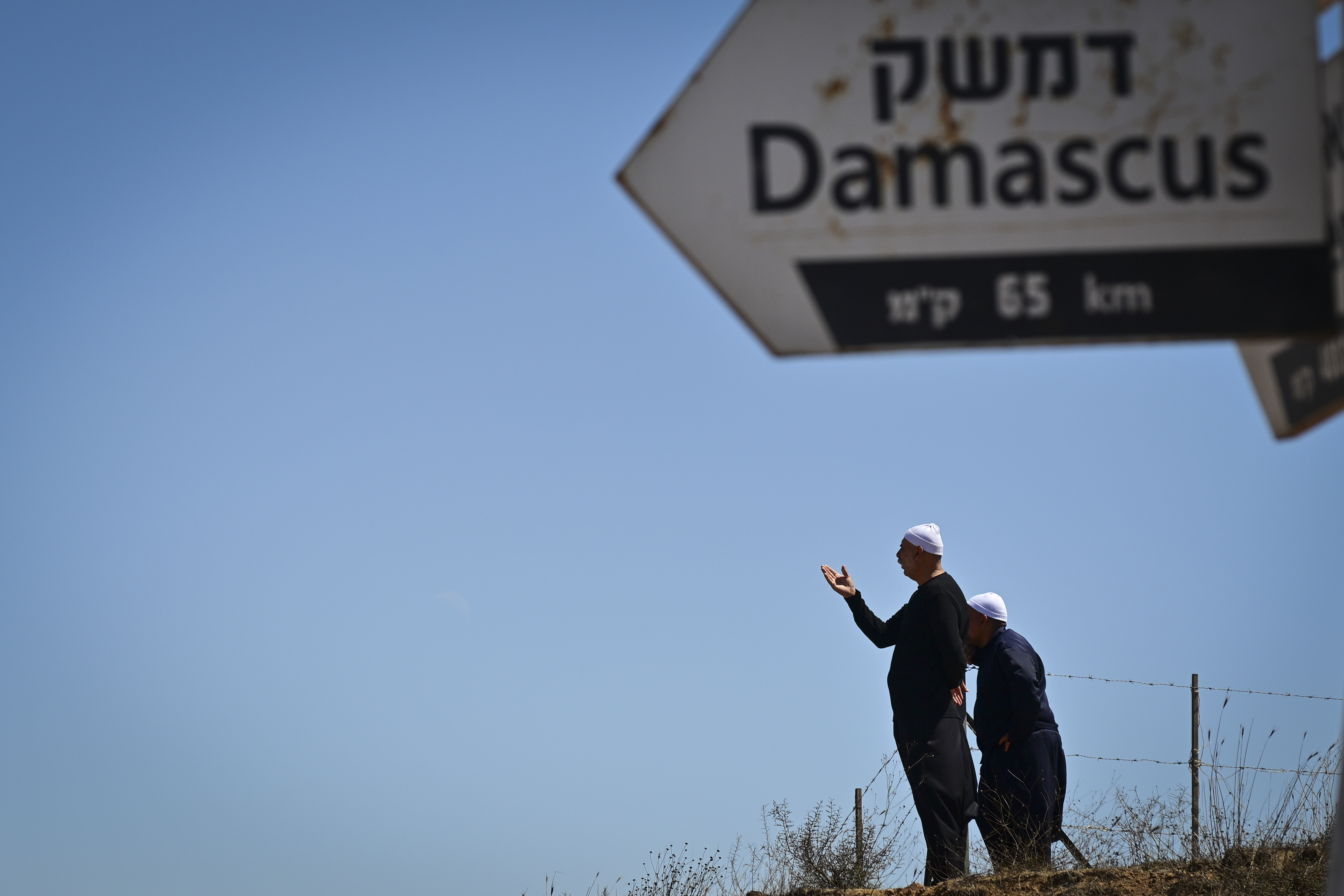People look at the view on Mount Bental, overlooking the border with Syria, in the Golan Heights on August 30, 2025. 