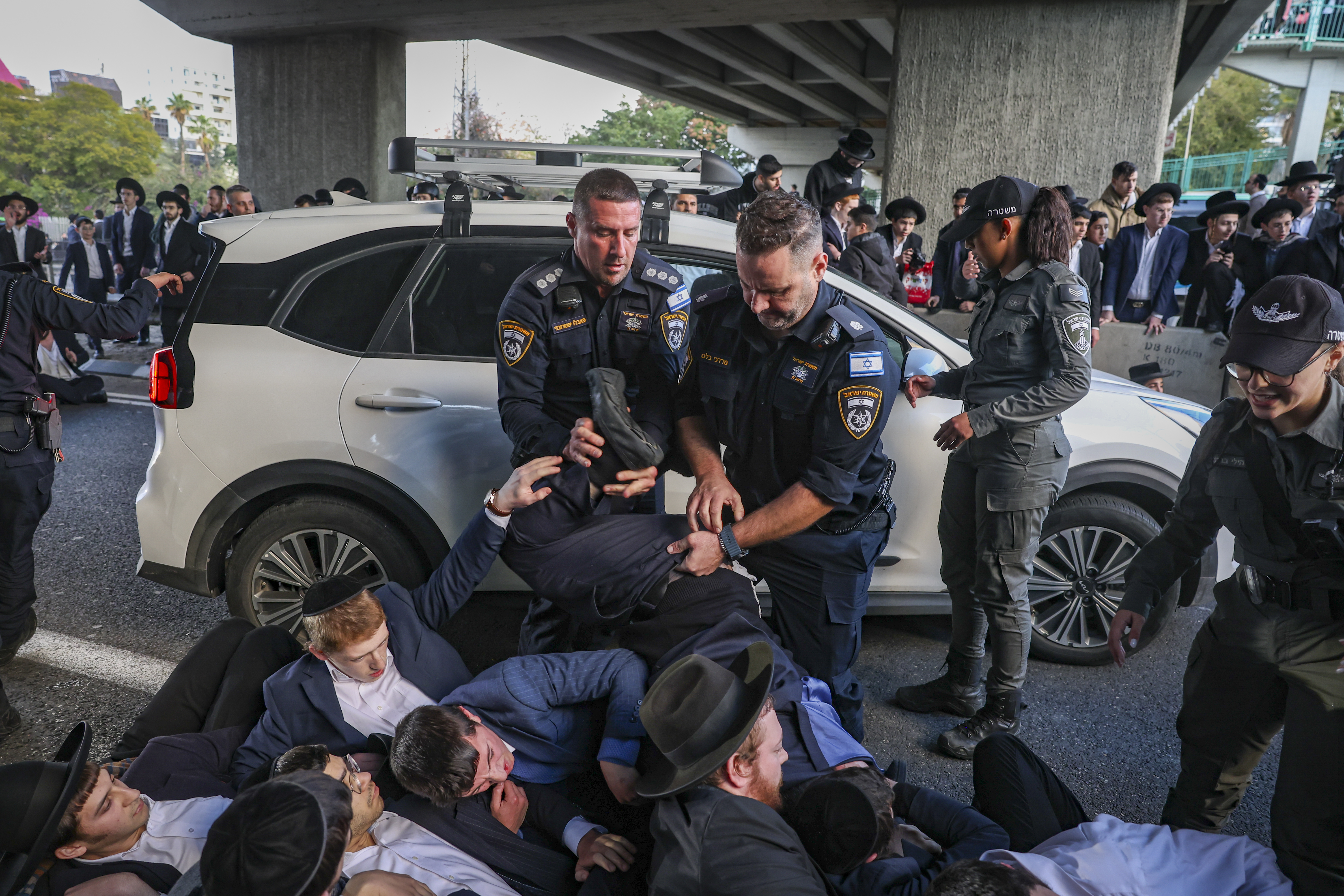 Ultra-Orthodox Jewish men block a road during a protest against the jailing of seminary students who failed to comply with an army recruitment order on Road 4 near Bnei Brak, December 28, 2025.