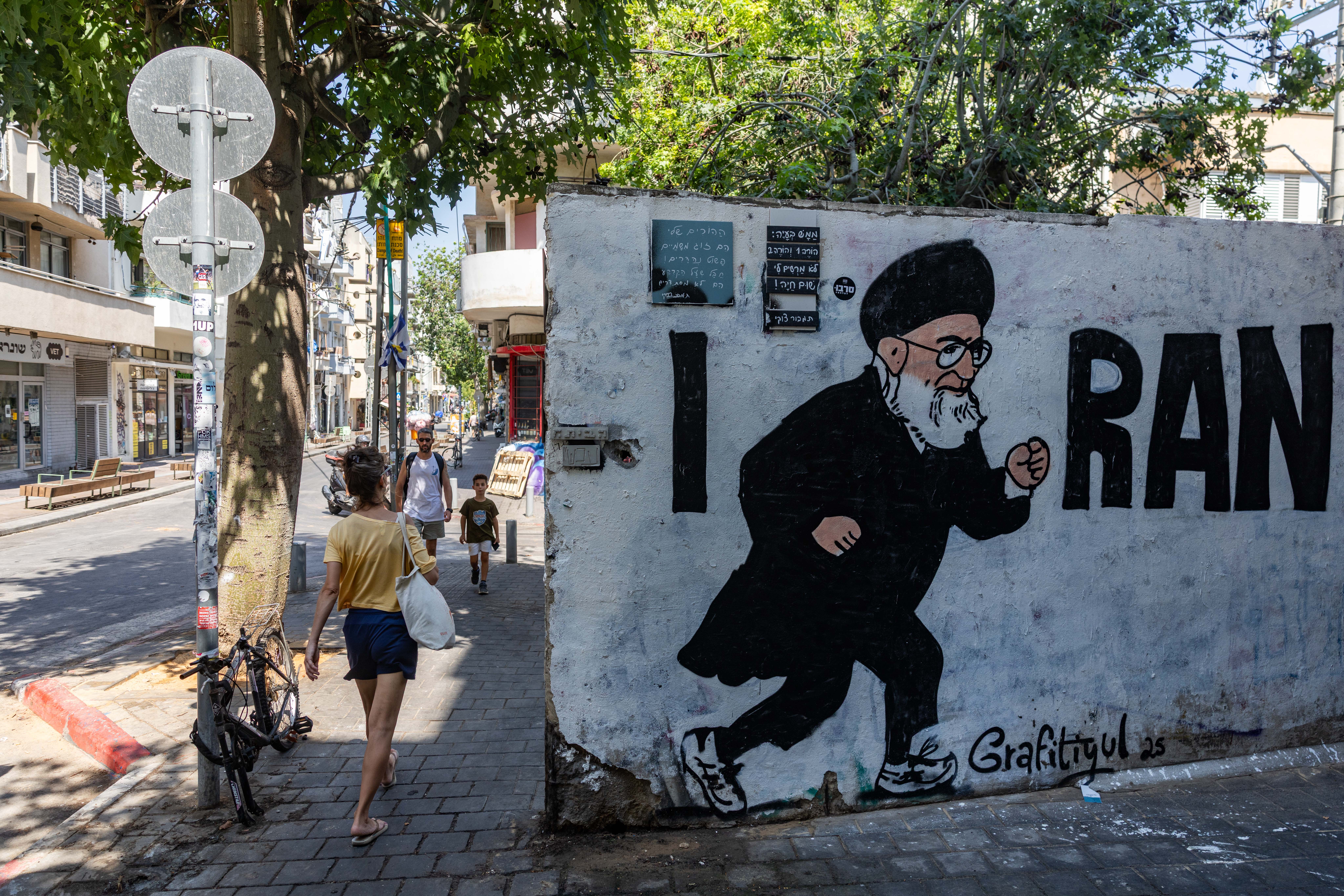A mural depicting Iran’s Supreme Leader Ayatollah Ali Khamenei running, alongside the phrase “I RAN,” is seen on a street wall in Tel Aviv, July 21, 2025.