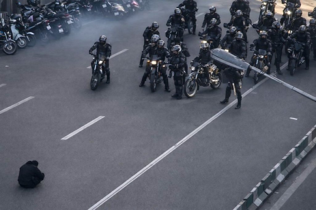 A lone protestor faces down Iranian regime forces.