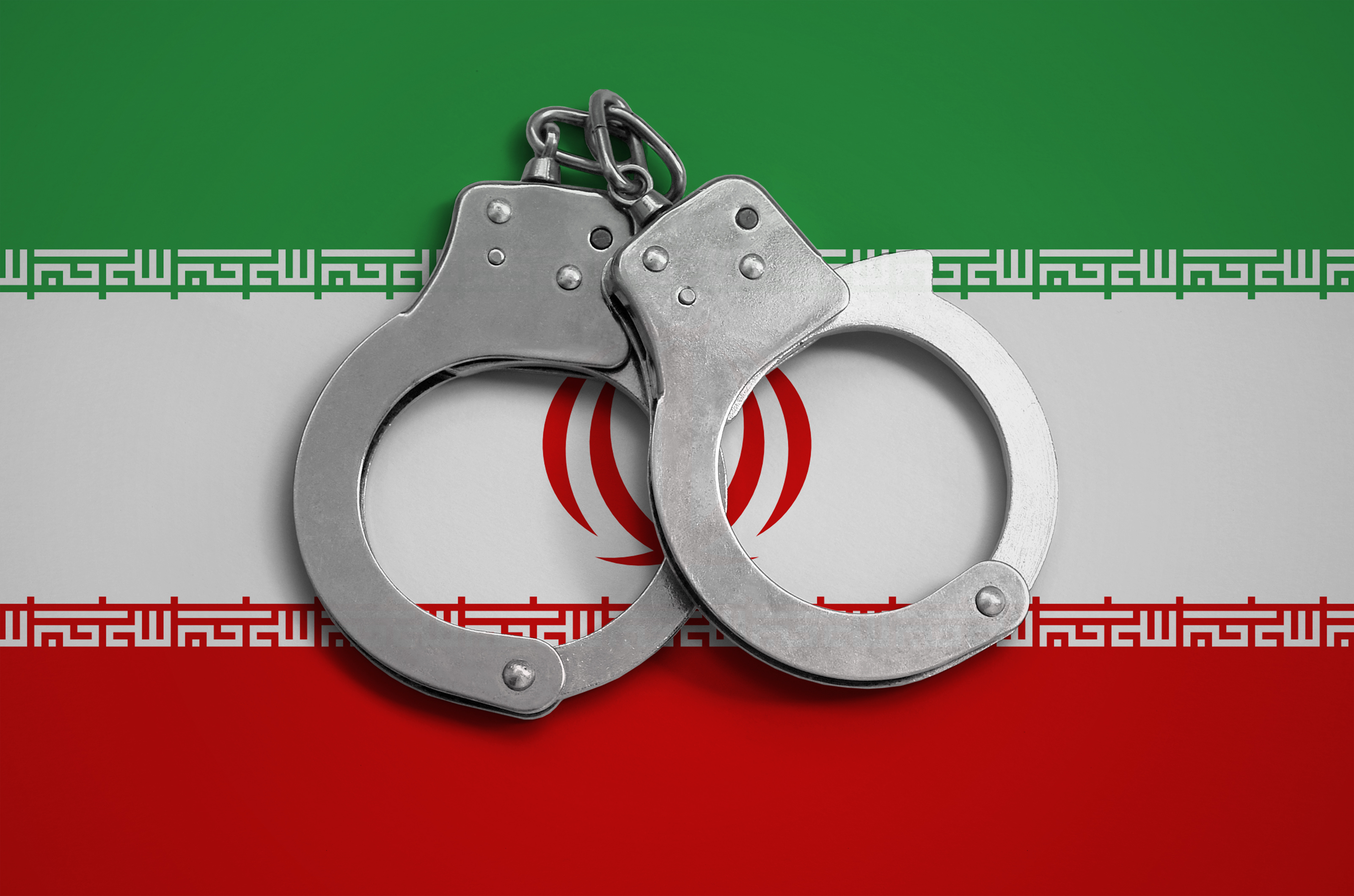 Handcuffs on background of Iranian flag