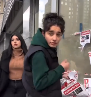 Aya and Dana Baraket tearing down posters of kidnapped Israeli children 