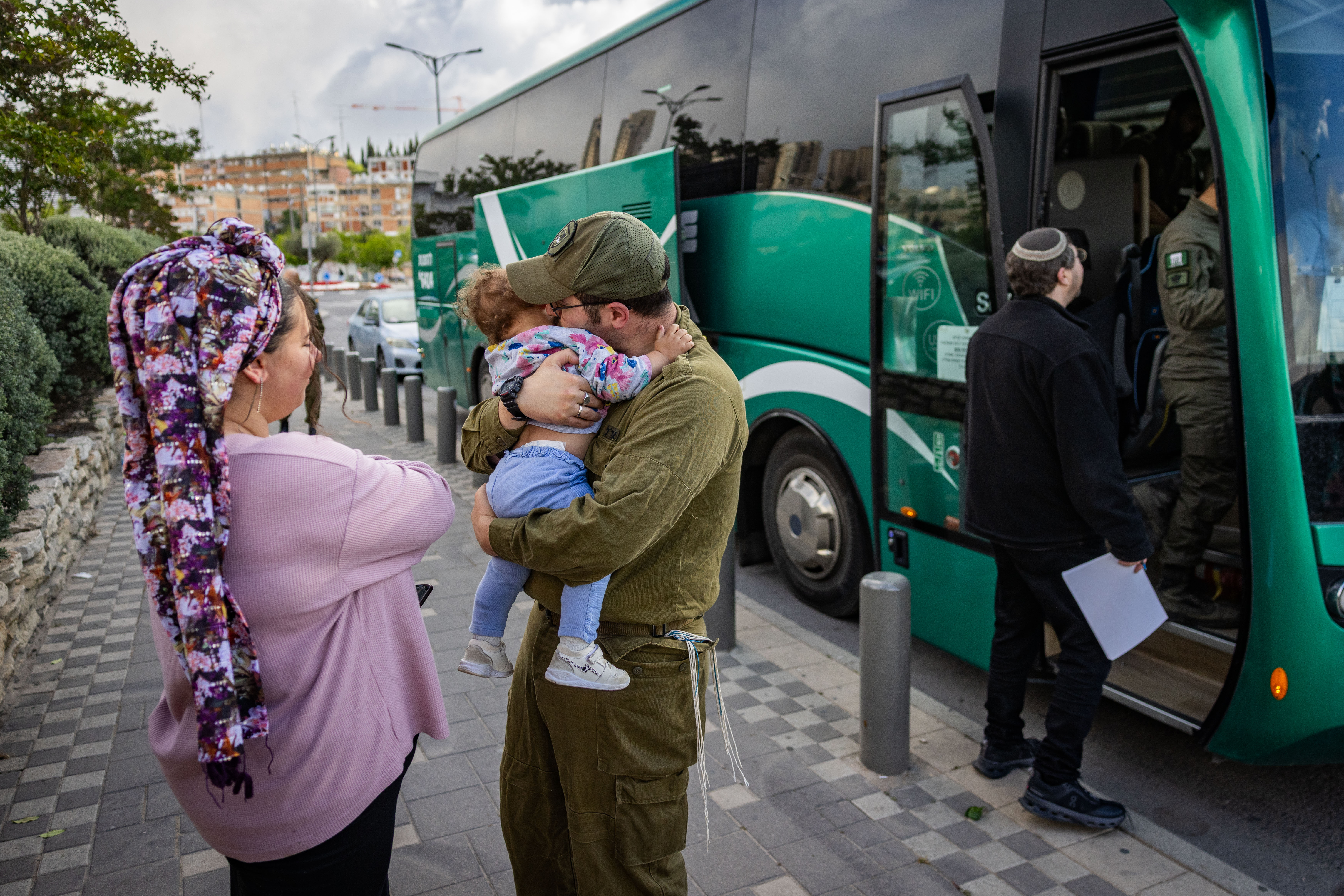 An Israeli reserve soldier kissing goodbye his child as he leaves for his deputy service, in Jerusalem, May 5, 2025.
