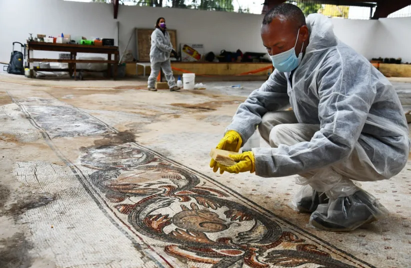 Man cleaning the Byzantine-era mosaic in Nahariya. File photo.