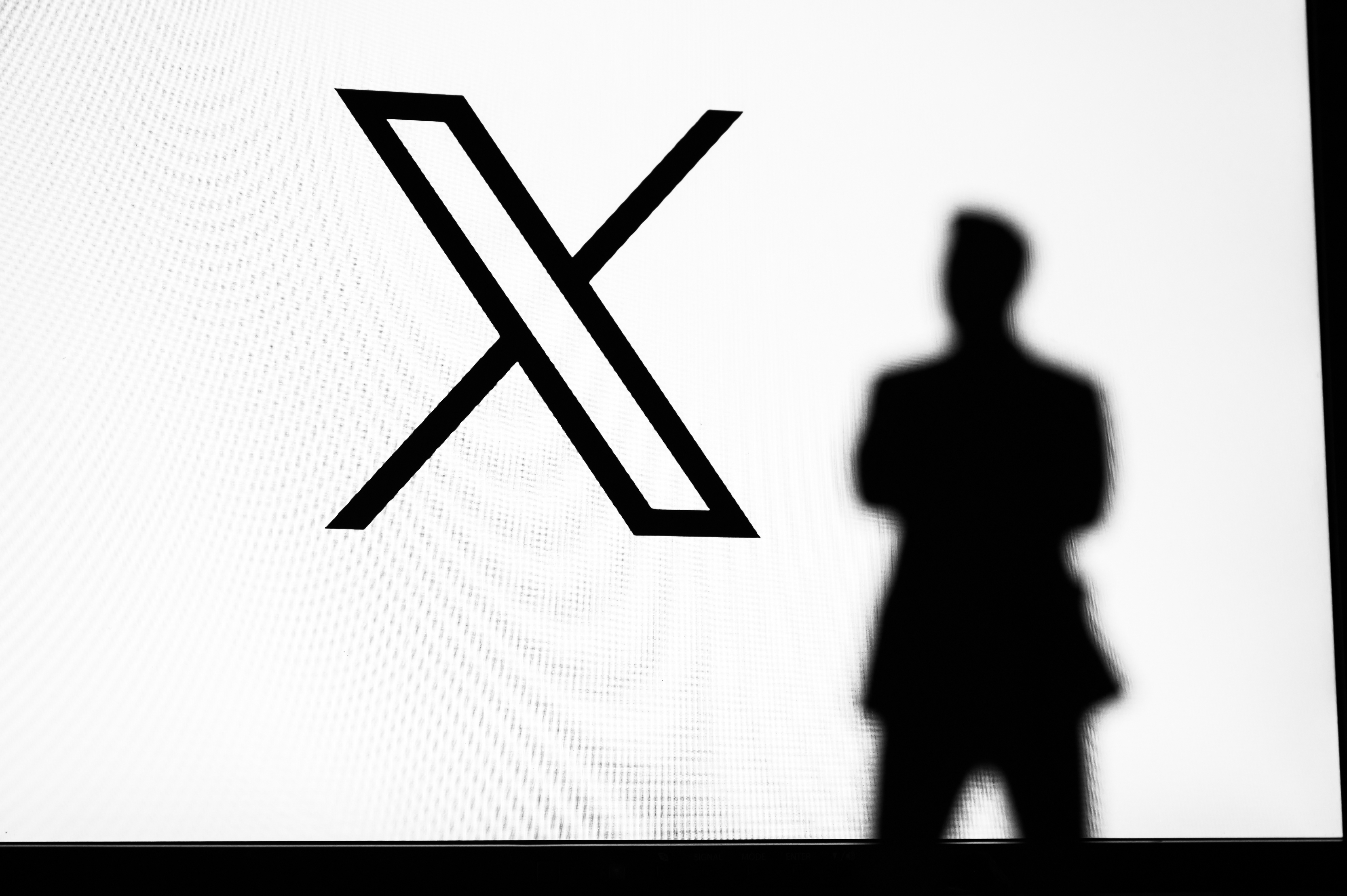X logo next to a man