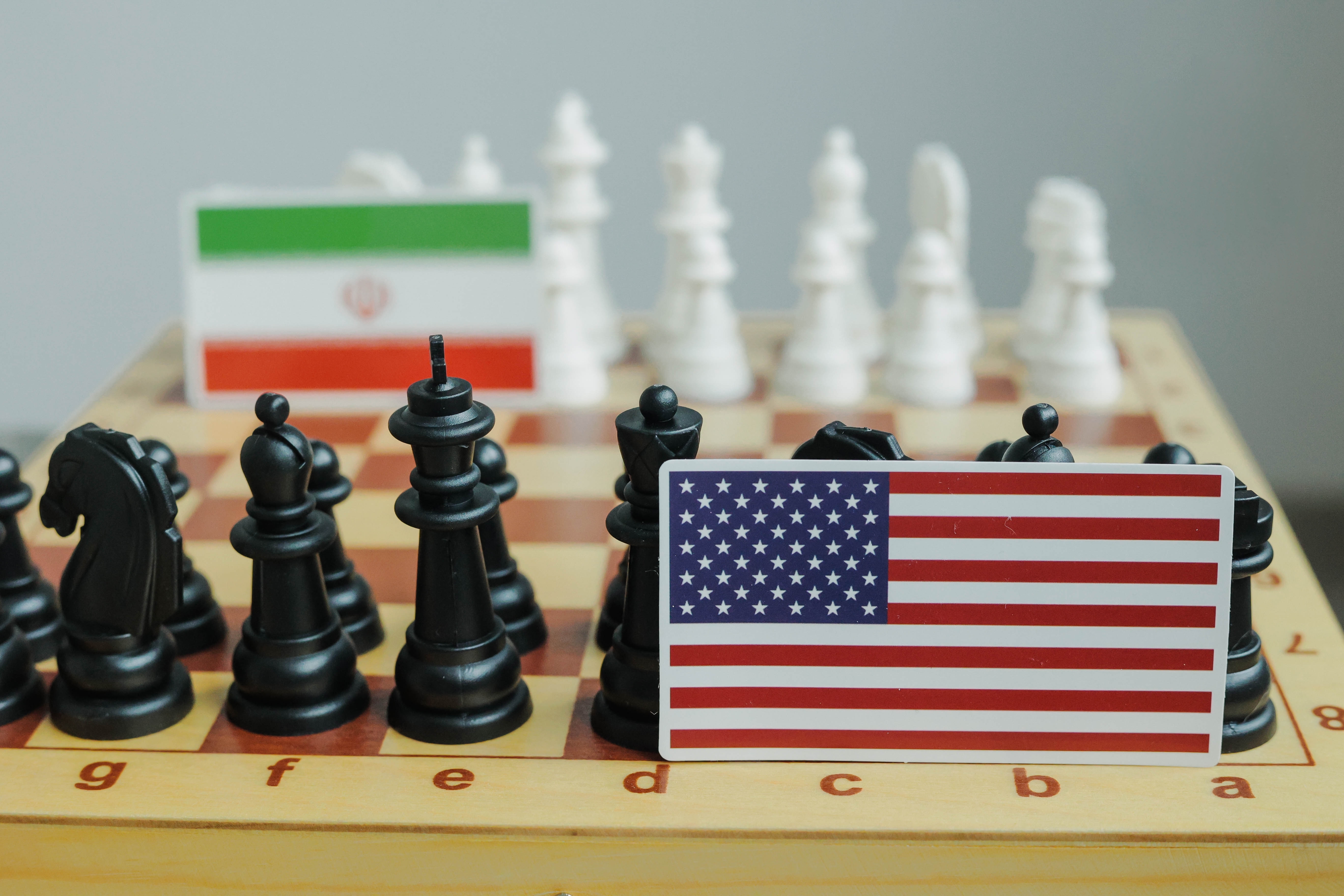 Flag of USA and a Iranian flag on chessboard. Conflict between those two countries.