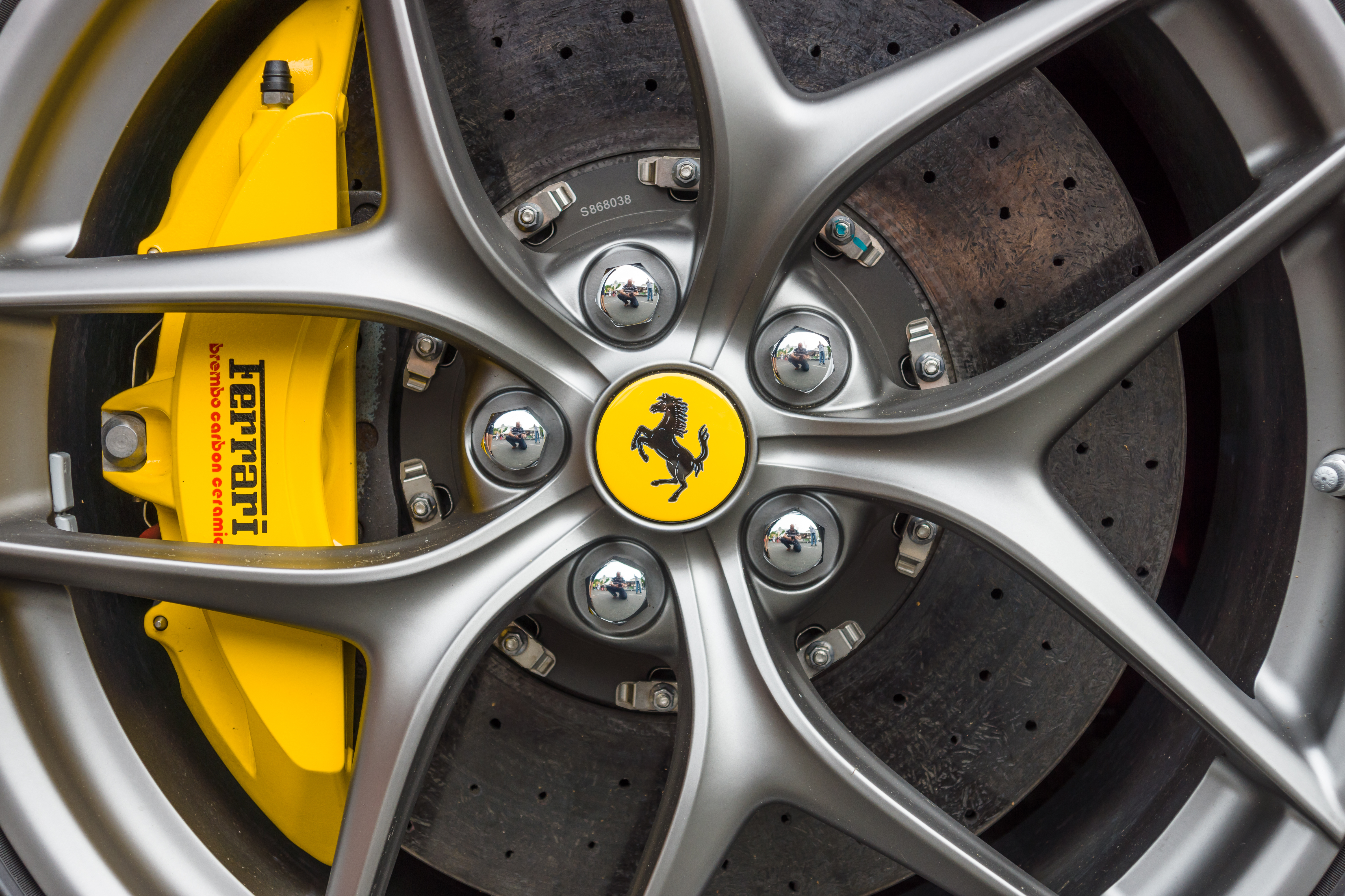 The wheel and brake system of a Ferrari sports car.