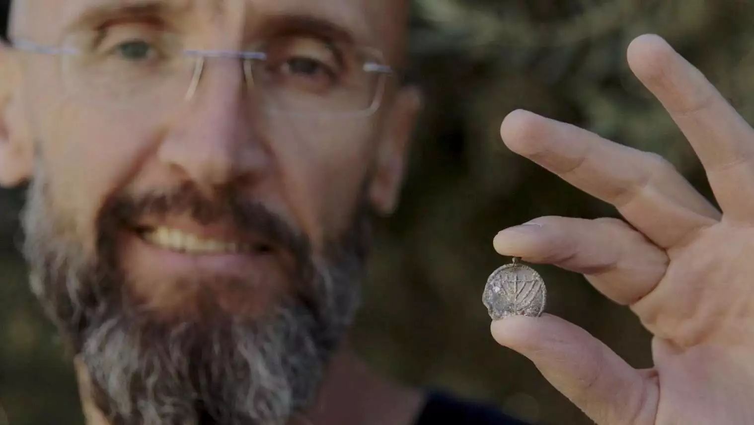 Dr. Filip Vukosavović holding the menorah pendant.