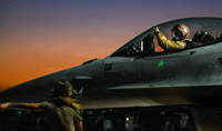 A U.S. Air Force fighter pilot performs pre-flight checks on an F-16 fighter jet.