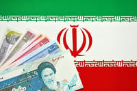 Iranian Rial IRR banknotes from Iran on flag of Islamic Republic of Iran close up