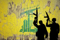 Flag of Hezbollah painted on the cracked wall with terrorist shadow