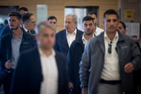The Prime Minister is surrounded by Shin Bet security agents.