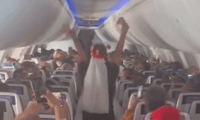 The bride cheers during the "wedding ceremony" on the plane.