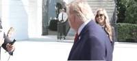 Trump's spokeswoman behind him, today