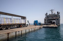 Aid offloading from the temporary pier before being damaged.