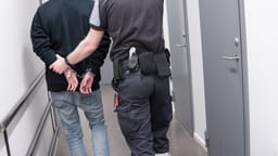 Prison guard escort arrested inmate through jail corridor