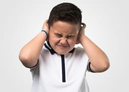 Little boy covering ears
