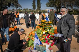 Mourners near the fresh grave of late Israeli hostages Shiri Bibas and her children Ariel and Kfir at the cemetery in Tzohar, southern Israel, February 26, 2025.