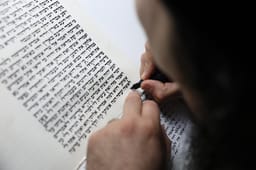 Nadav Elhadad, a Sefer Torah scribe, sofer stam, from the "Har Sinai" foundation, seen scribing a new Torah scroll in the Northern Israeli town of Tzfat. February 10, 2025.
