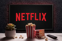  Netflix logo on TV with popcorn boxes, remote control